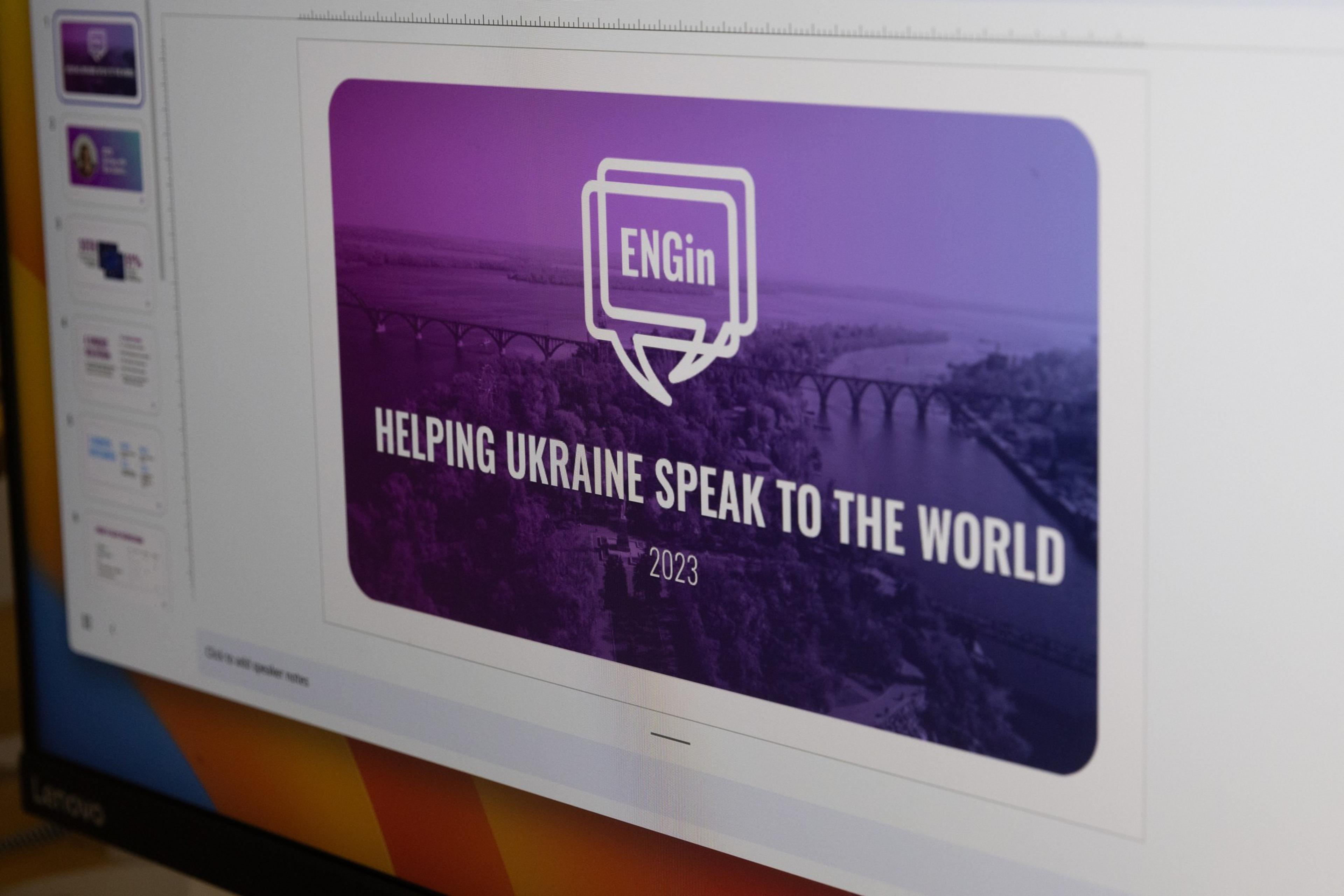 A presentation slide reads "ENGin" with the slogan "Helping Ukraine speak to the world" and the year 2023, over a purple-toned image of a river and bridge.