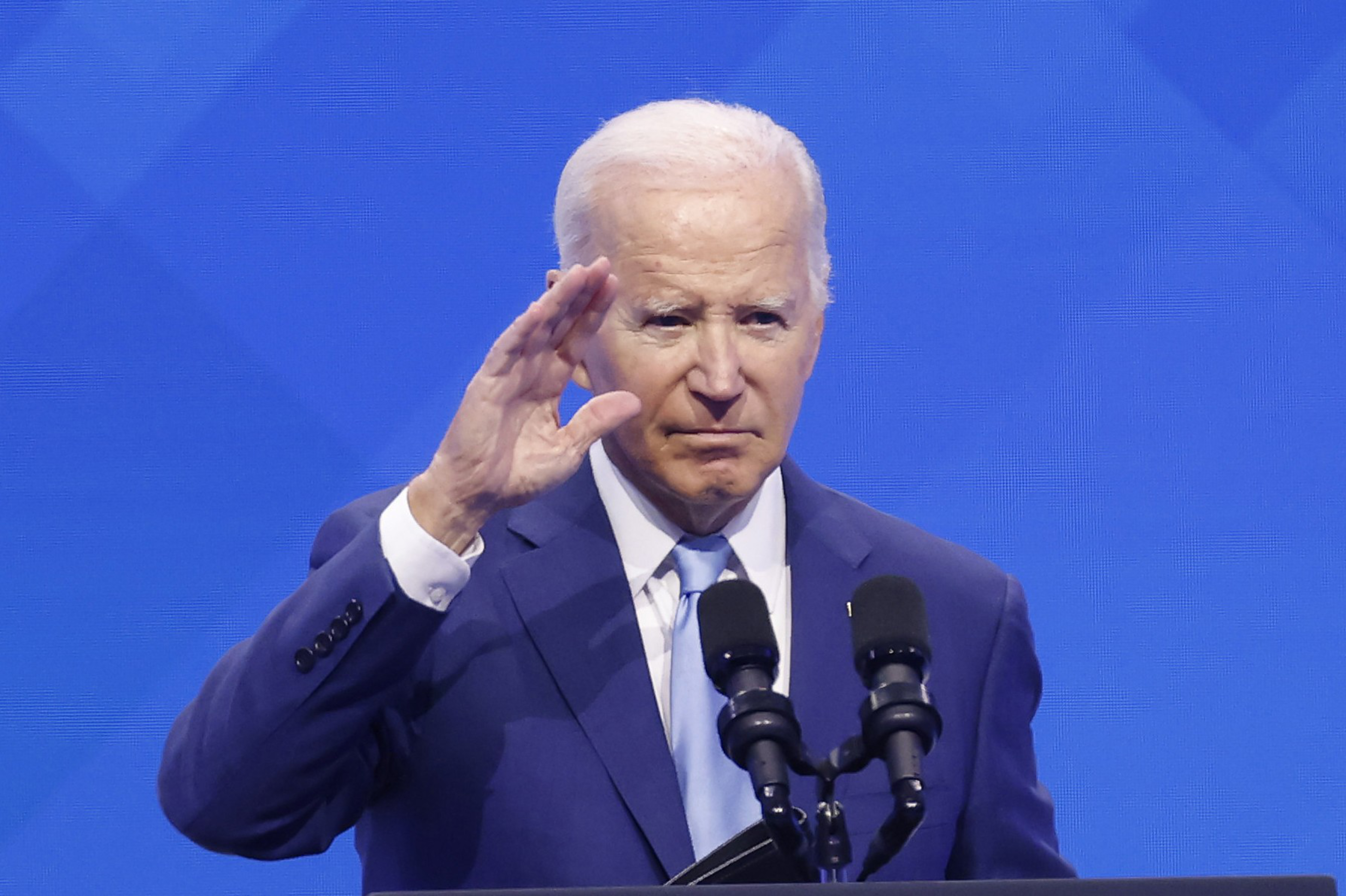 Man holds hand up to face while speaking in mic