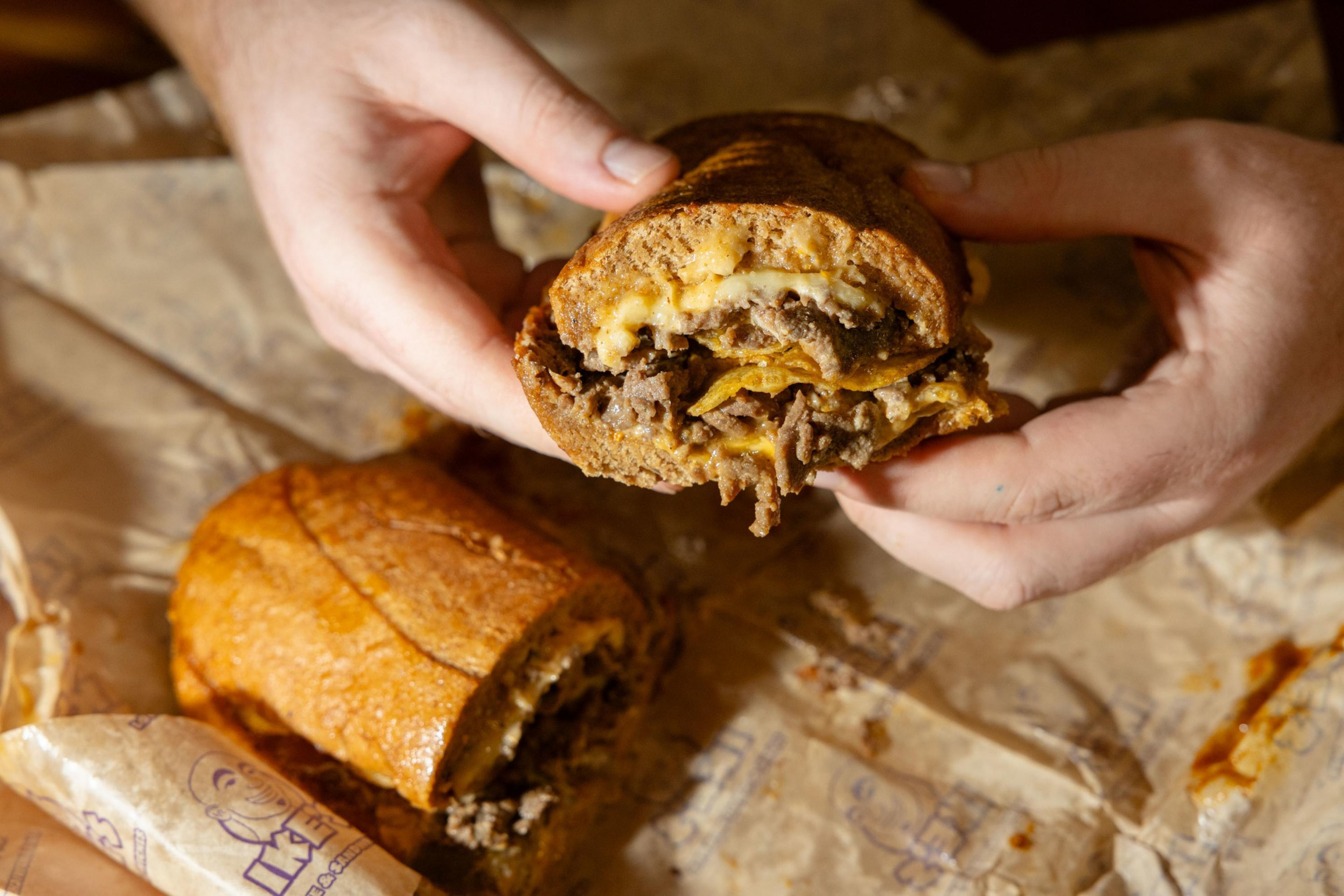 A close-up of a cheesy steak sandwich.