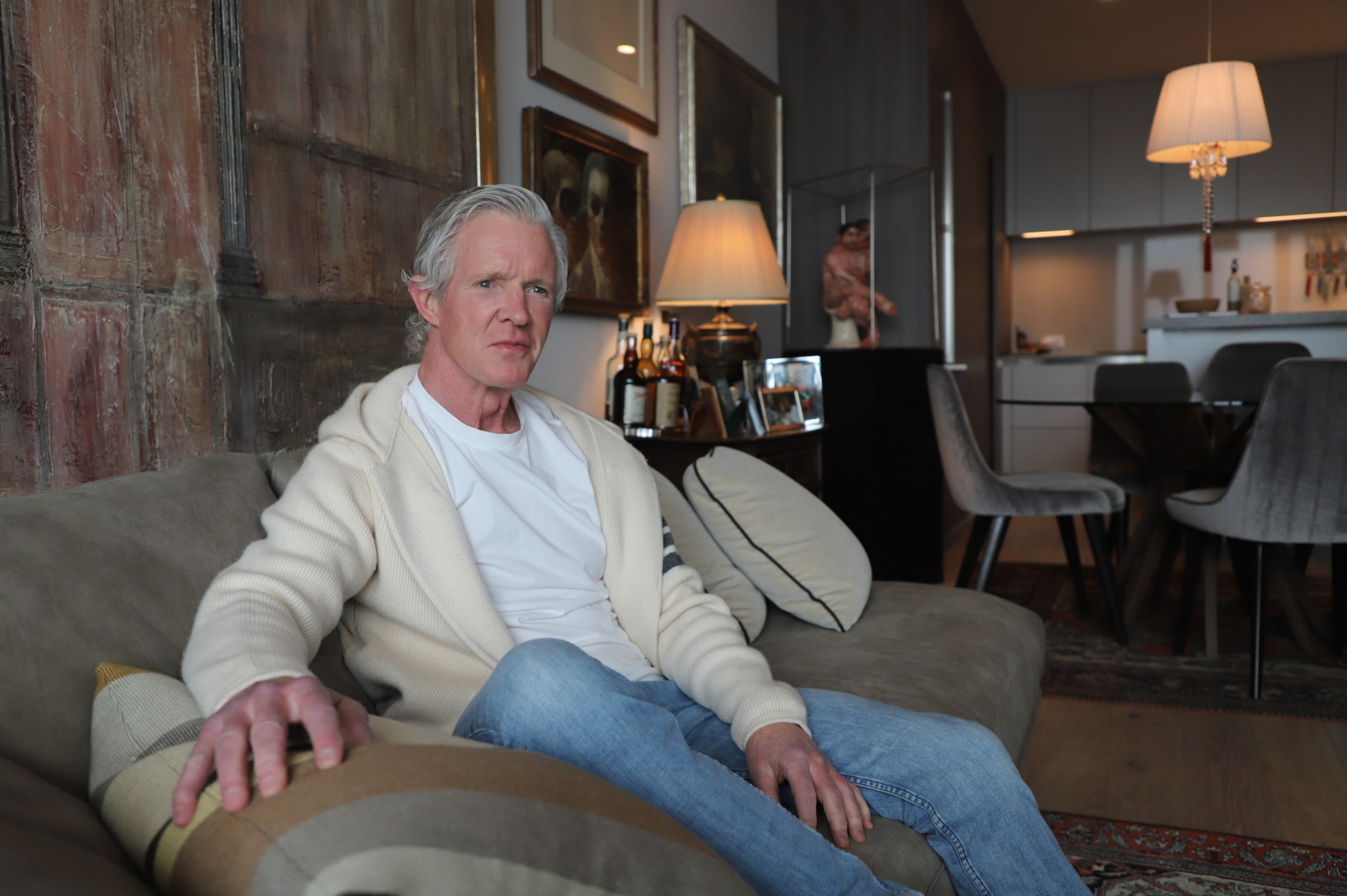 A man sits inside a fancy condo.