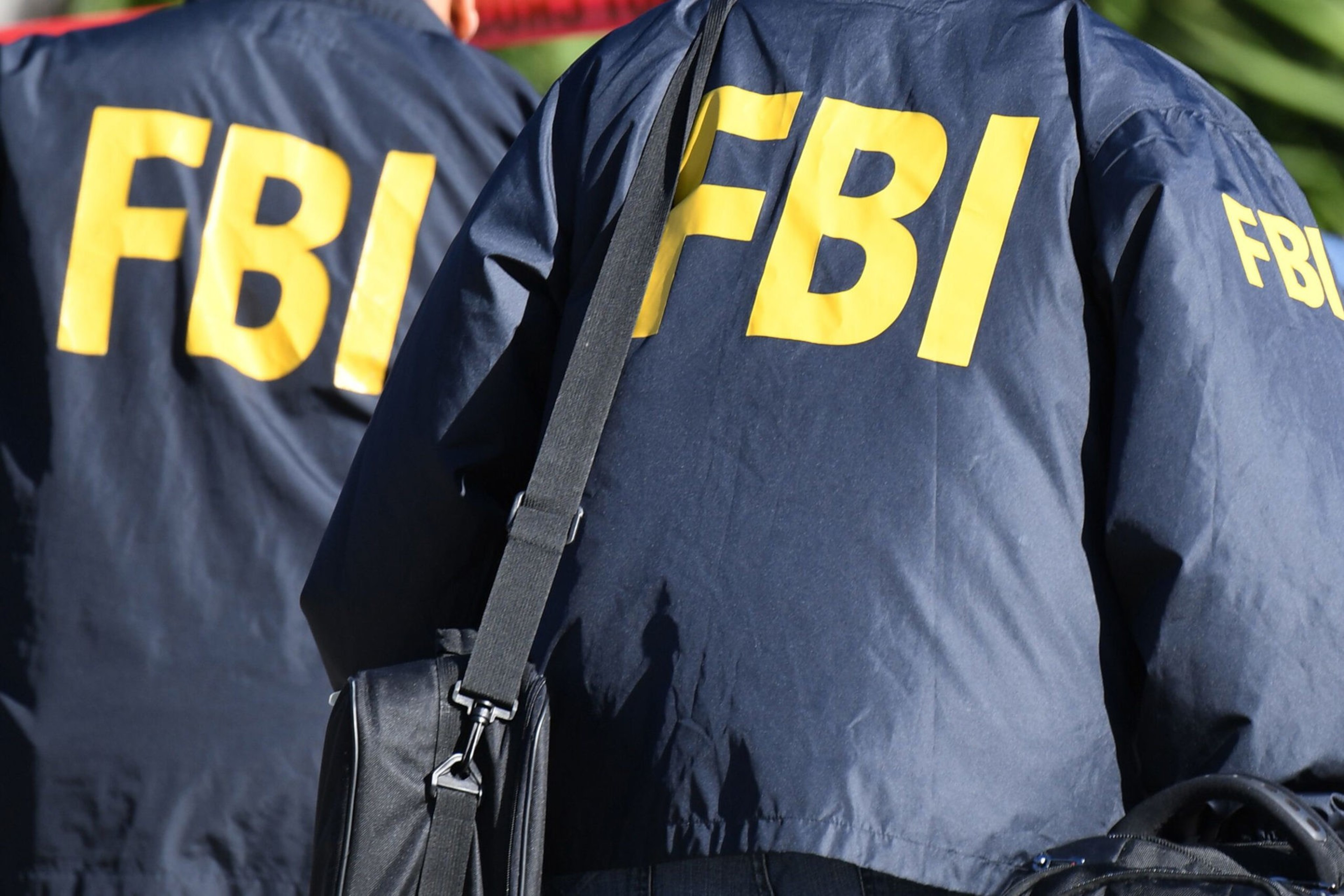 Two people in FBI coats stand side by side.