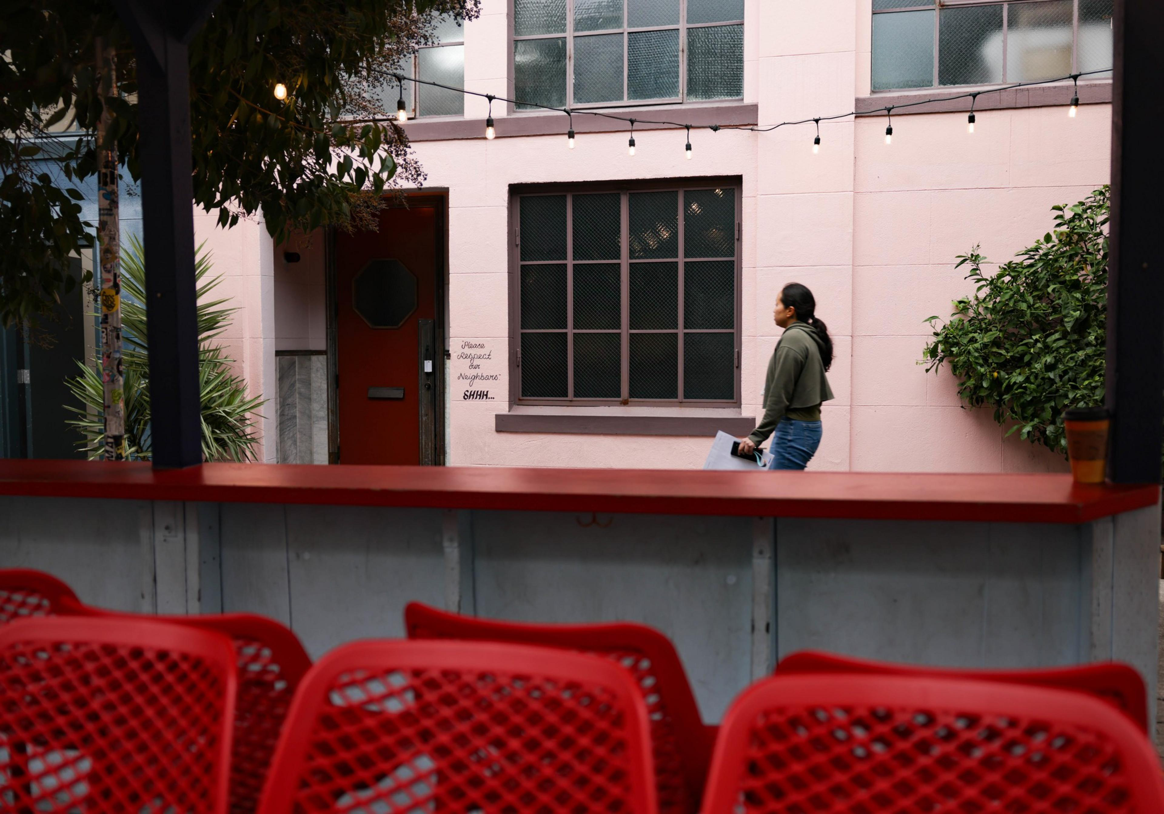 a pink bar is seen from inside its parklet