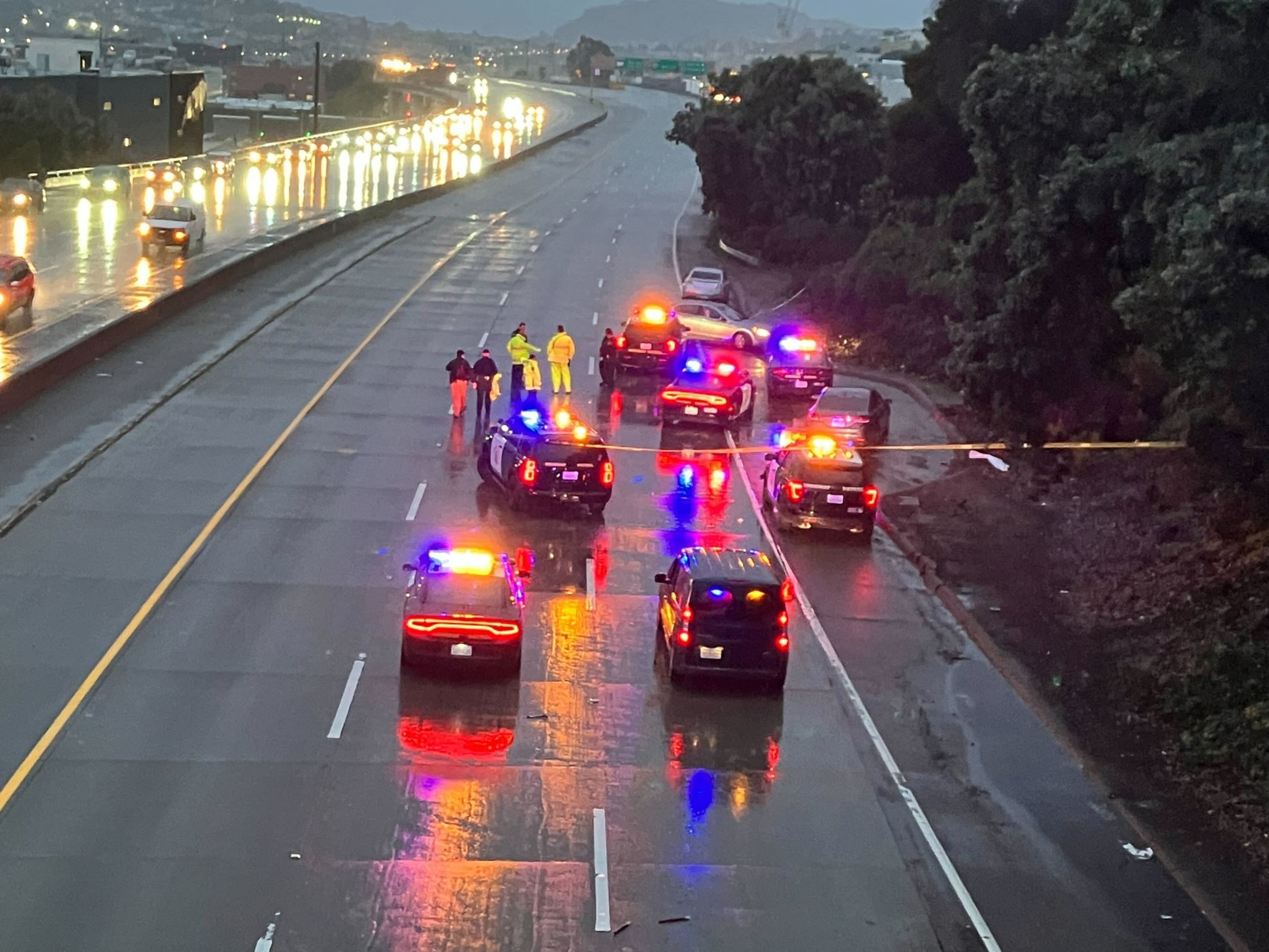 Law enforcement officials and vehicles with their lights parked on freeway