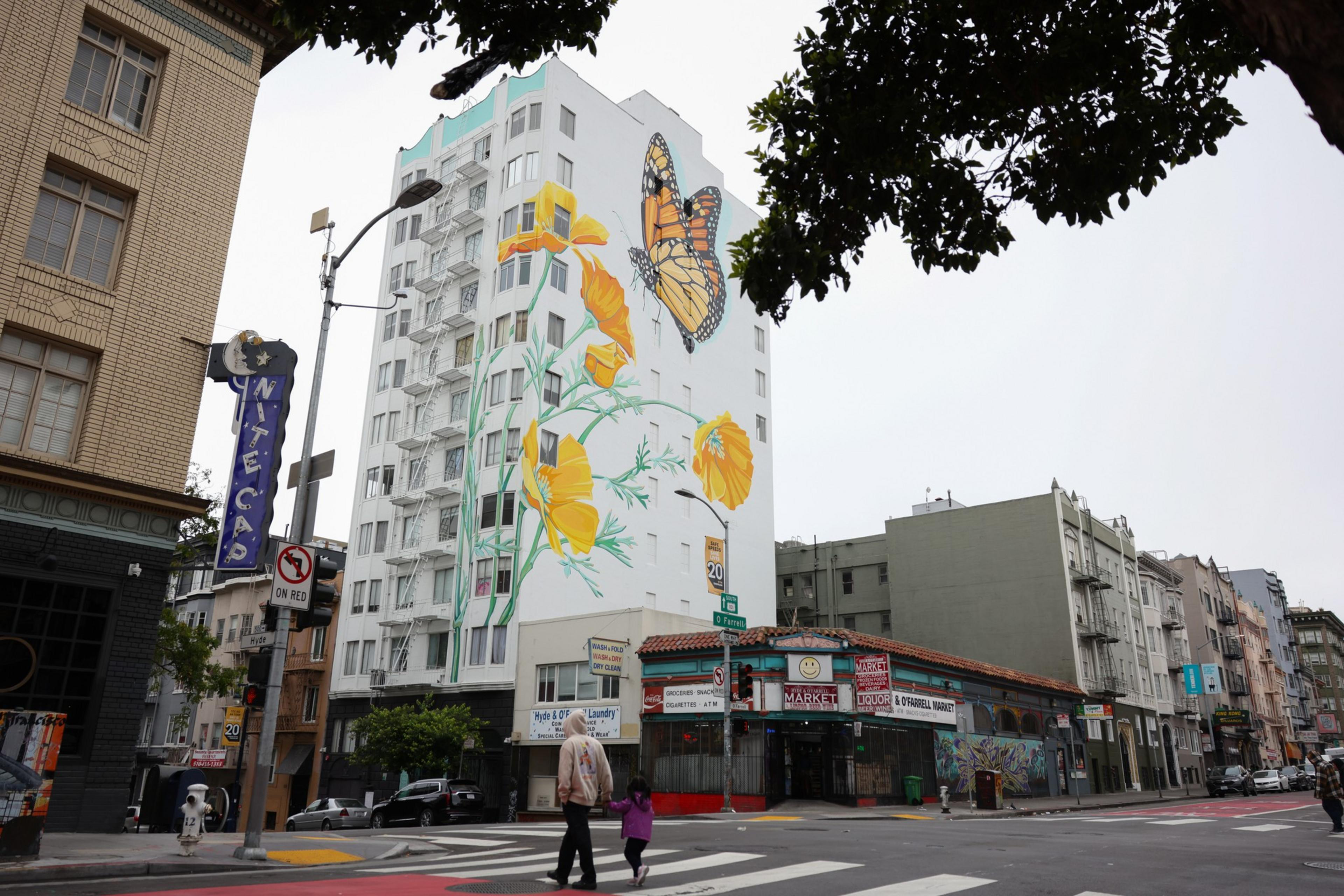 Painting of butterflies and poppies on the side of a multi-story building