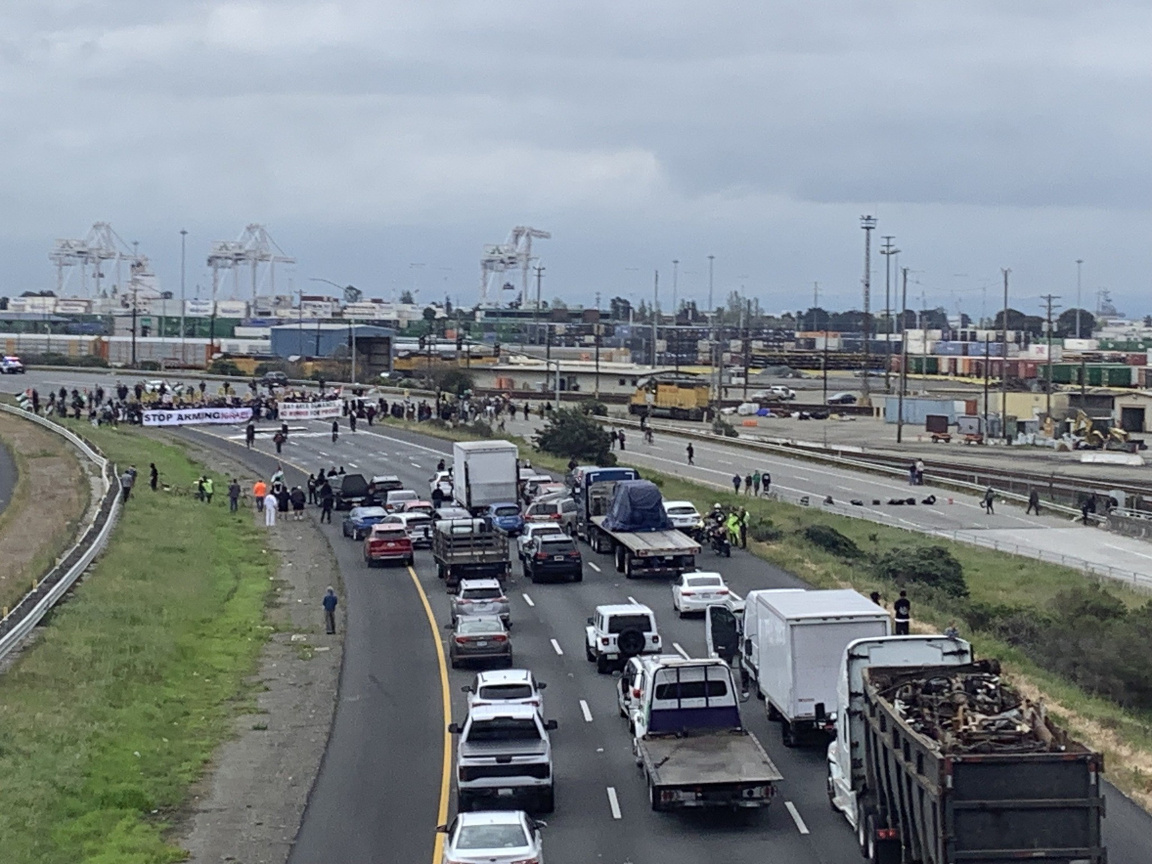 Backed up traffic on a highway pauses beside traffic lanes blocked by protesters