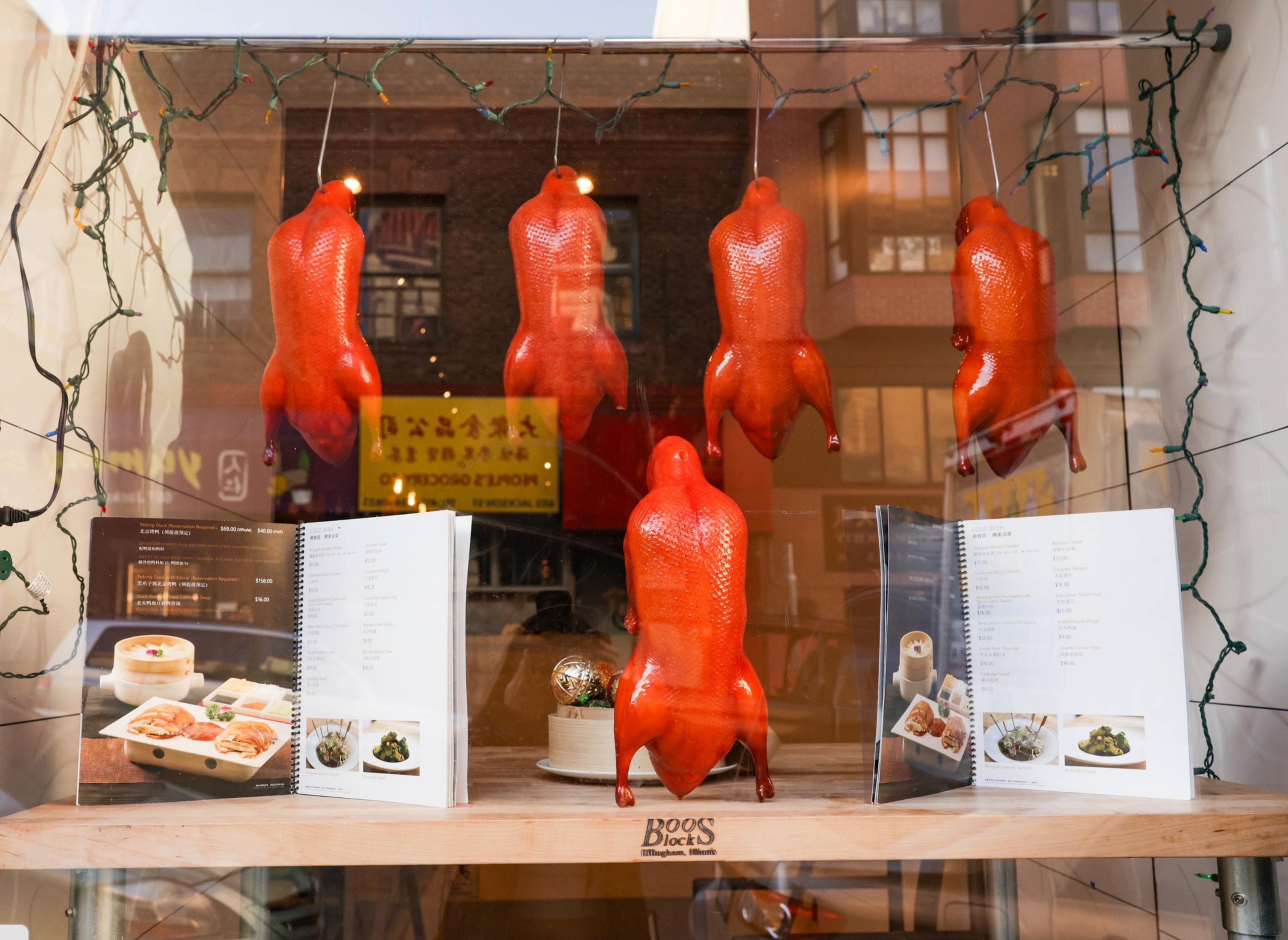 Fake duck hangs on hooks inside a restaurant
