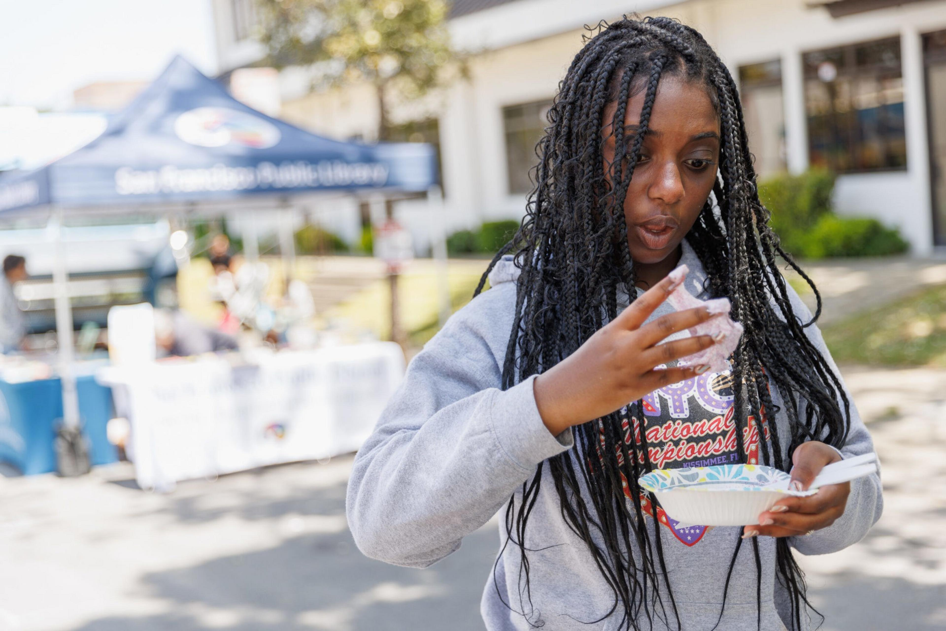 A woman seems surprised as she interacts with a goopy material with her hands.