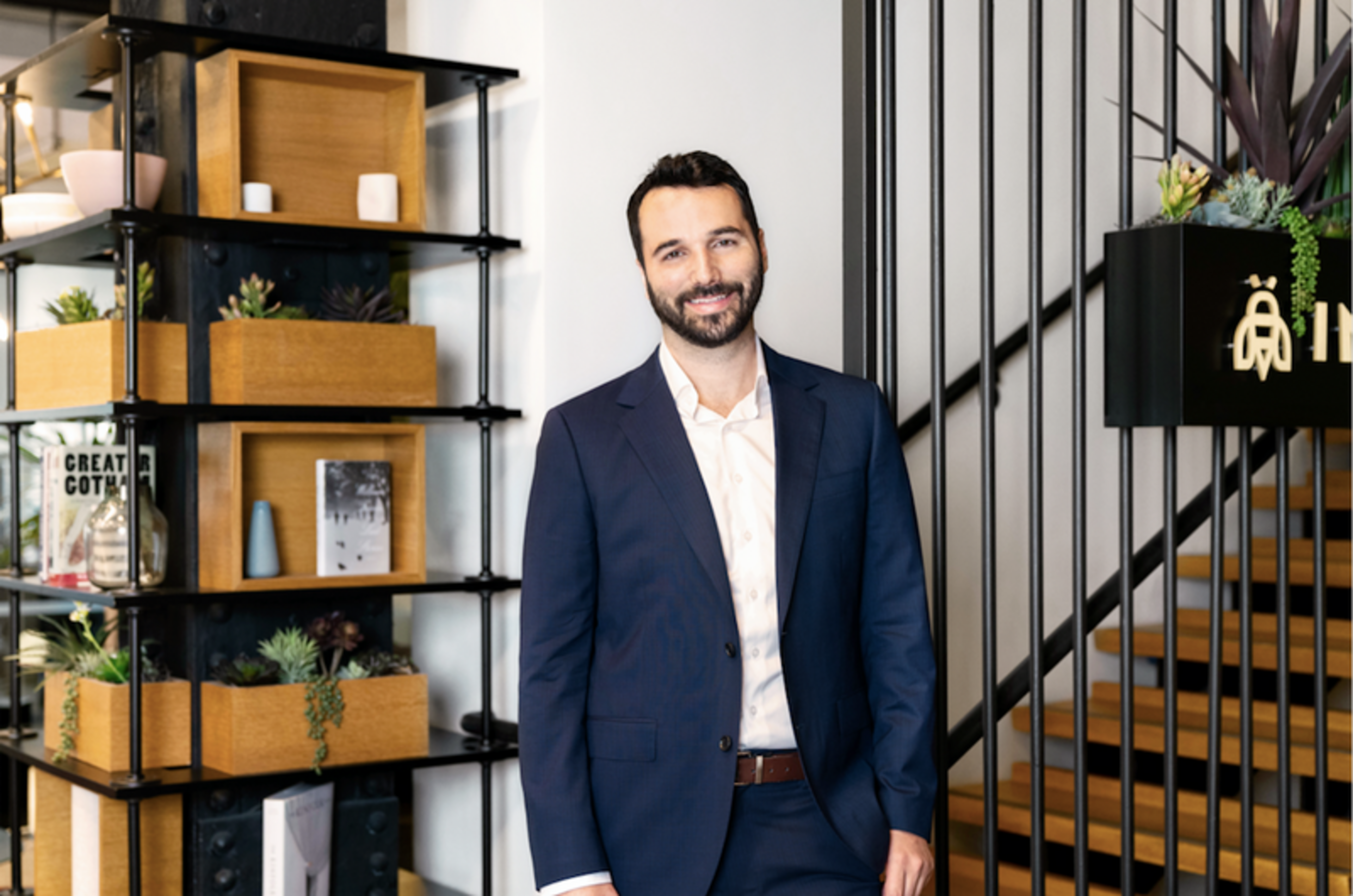 man stands in front of shelf and staircase