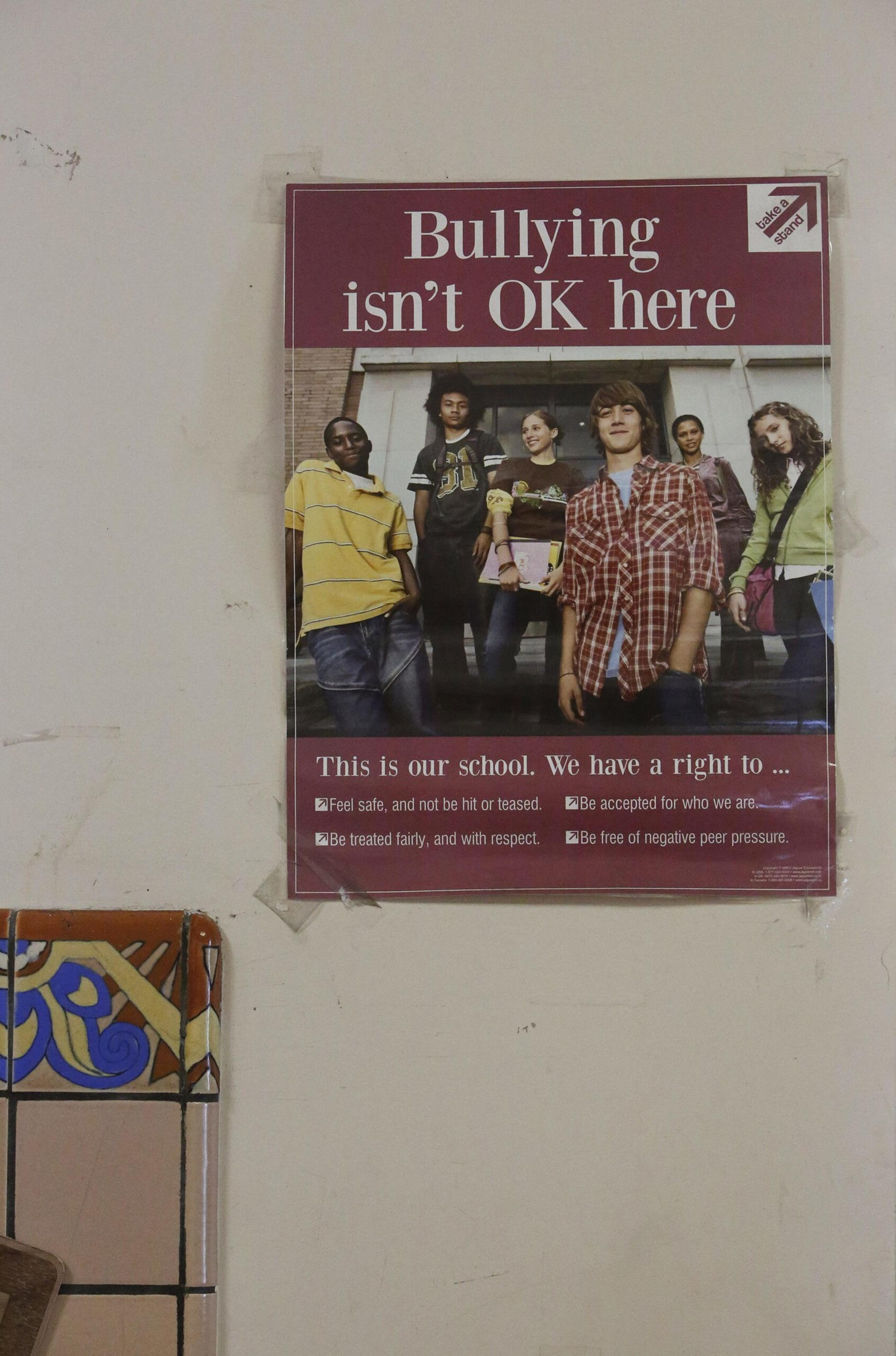 A poster with diverse teens reads "Bullying isn't OK here" and lists rights: to feel safe, be accepted, be treated fairly, and be free from negative peer pressure.