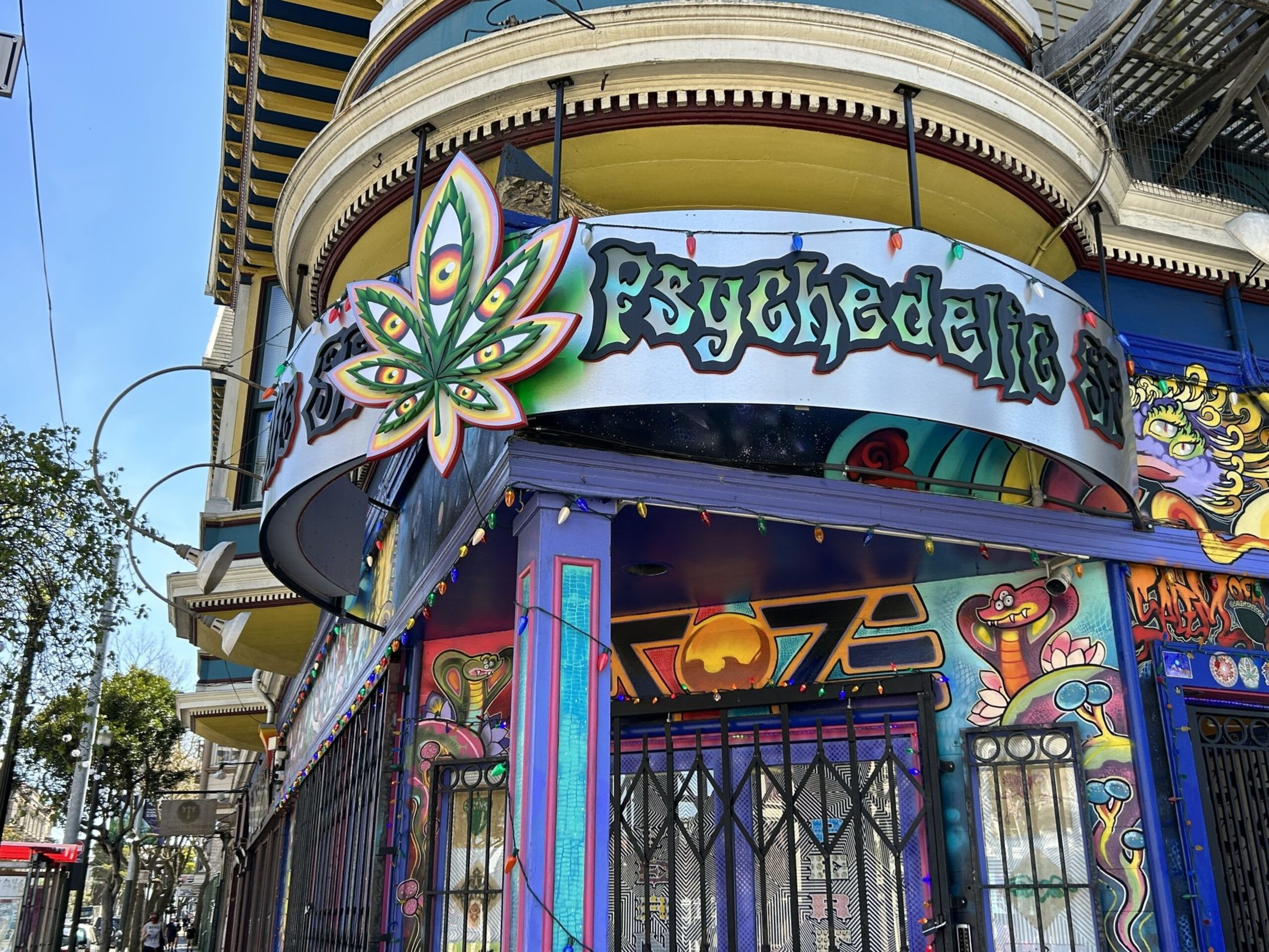 A colorful storefront with psychedelic art, featuring a stylized leaf design and the word "Psychedelic" in bold, vibrant letters.