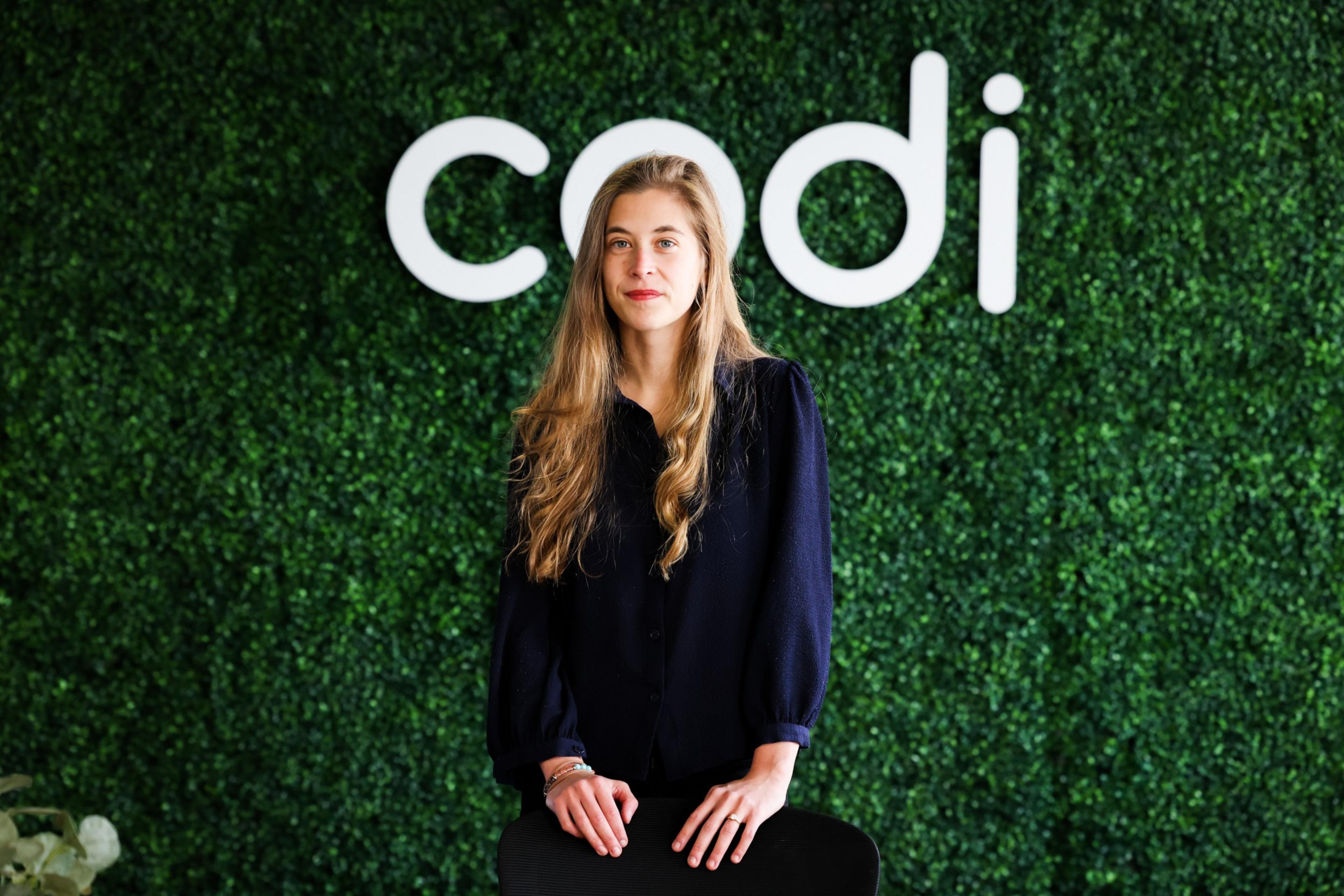 woman stands in front of a green background