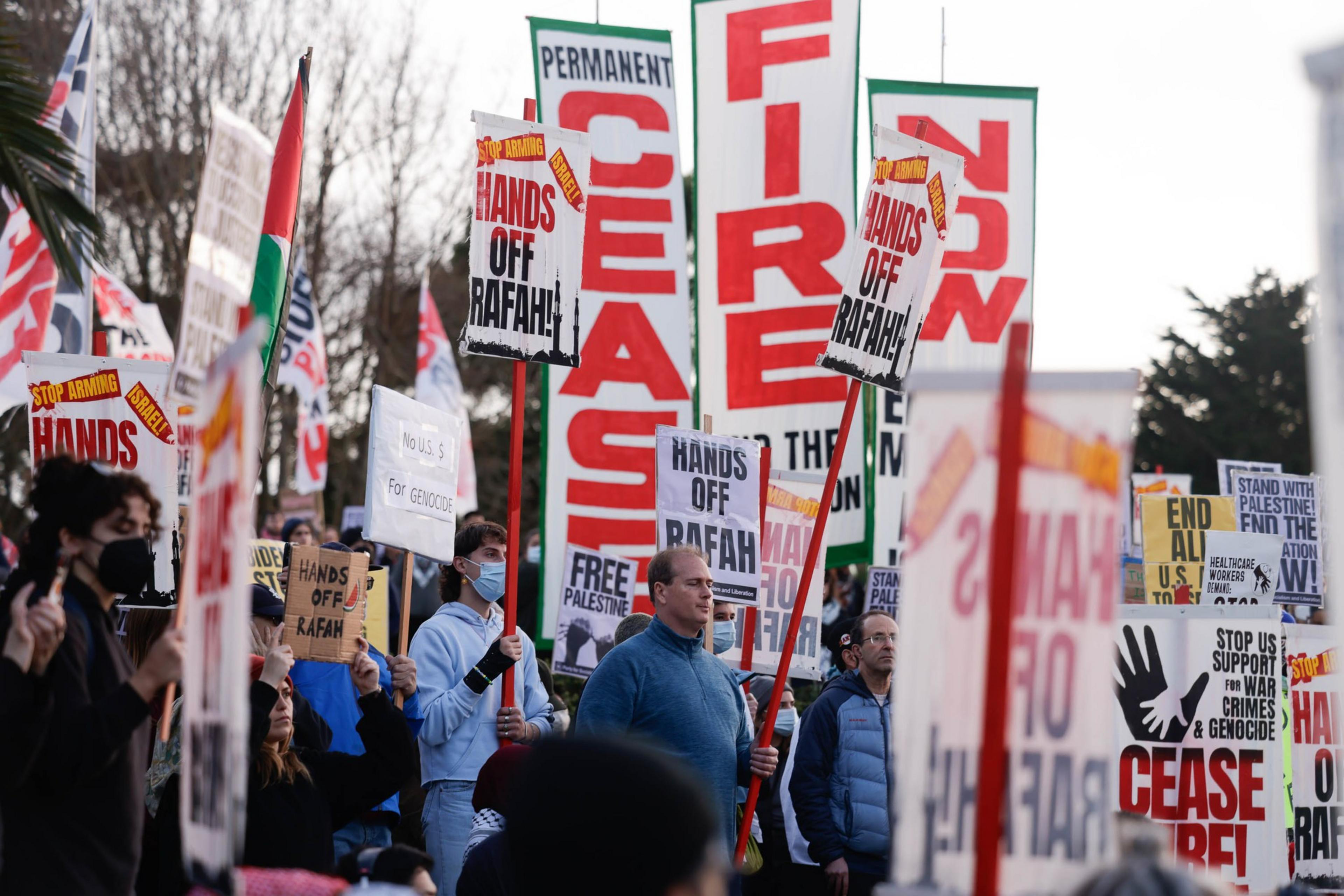 People carry signs in protest of U.S. involvement in the Israel-Hamas War