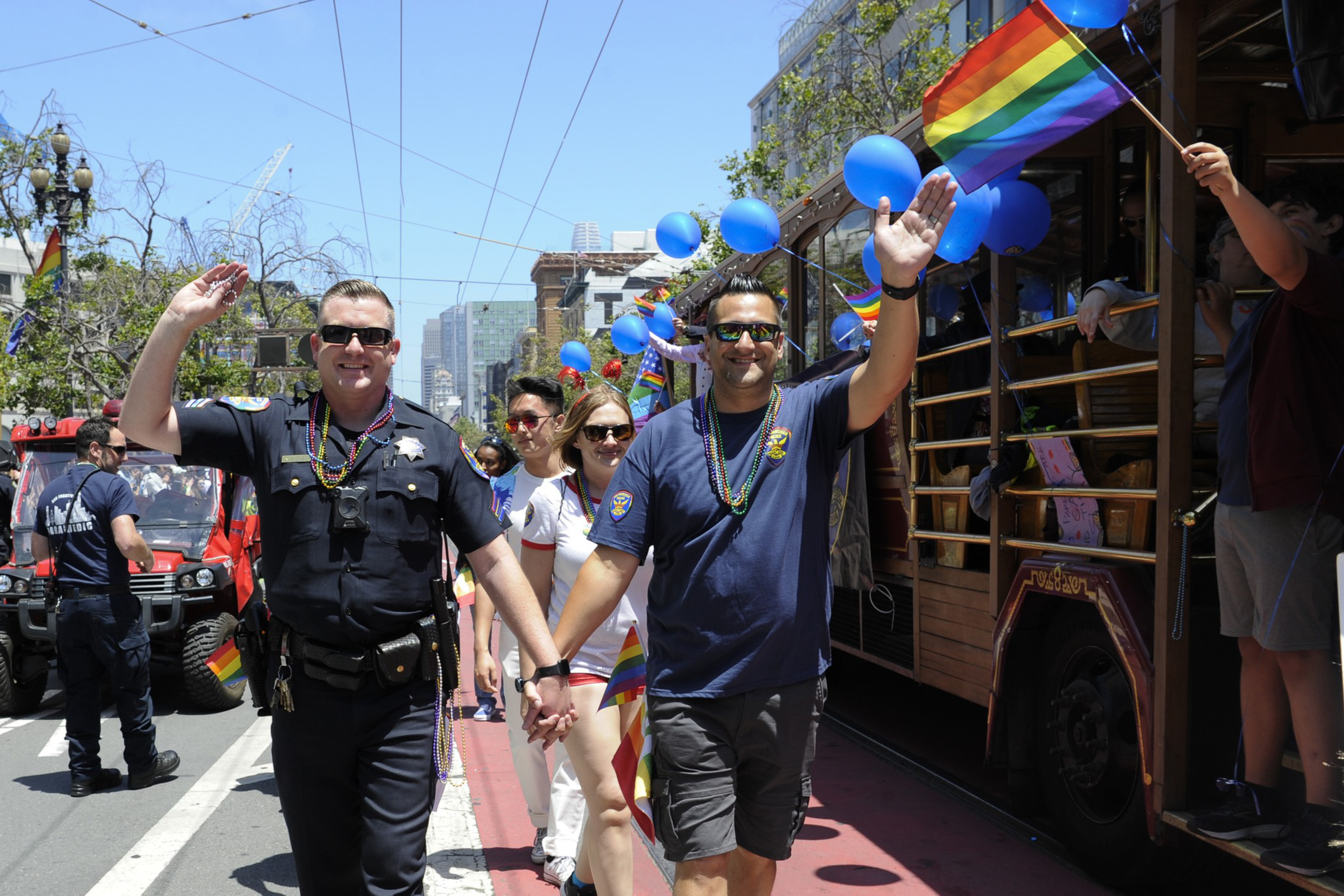 San Francisco policemen hold hands while walking during the San Francisco Pride Parade and Celebration on June 30, 2019, in San Francisco. I Photo by Arun Nevader, via Getty Images