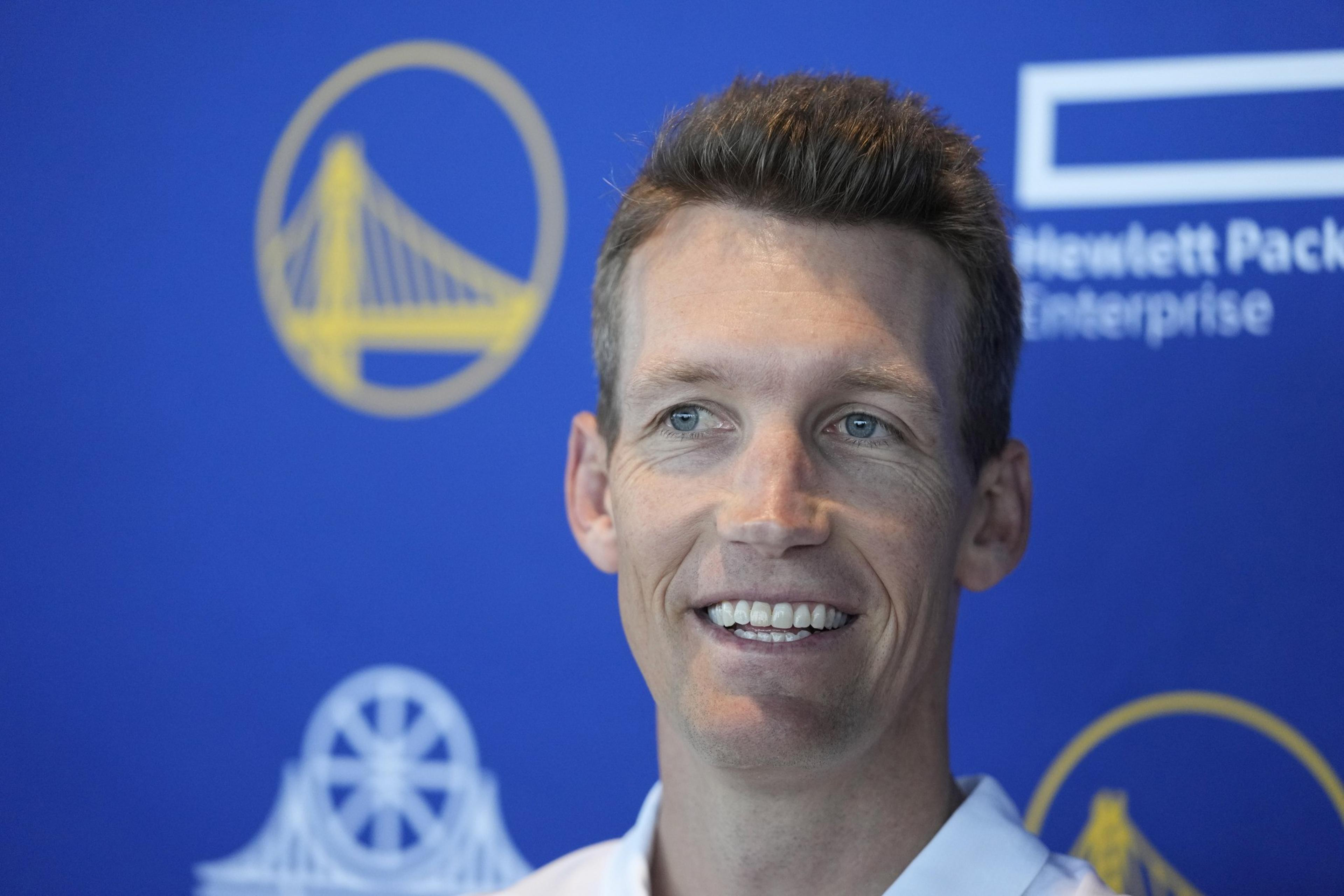 A person smiles against a blue background featuring a yellow circular bridge logo and &quot;Hewlett Packard Enterprise.&quot; The overall mood is positive.