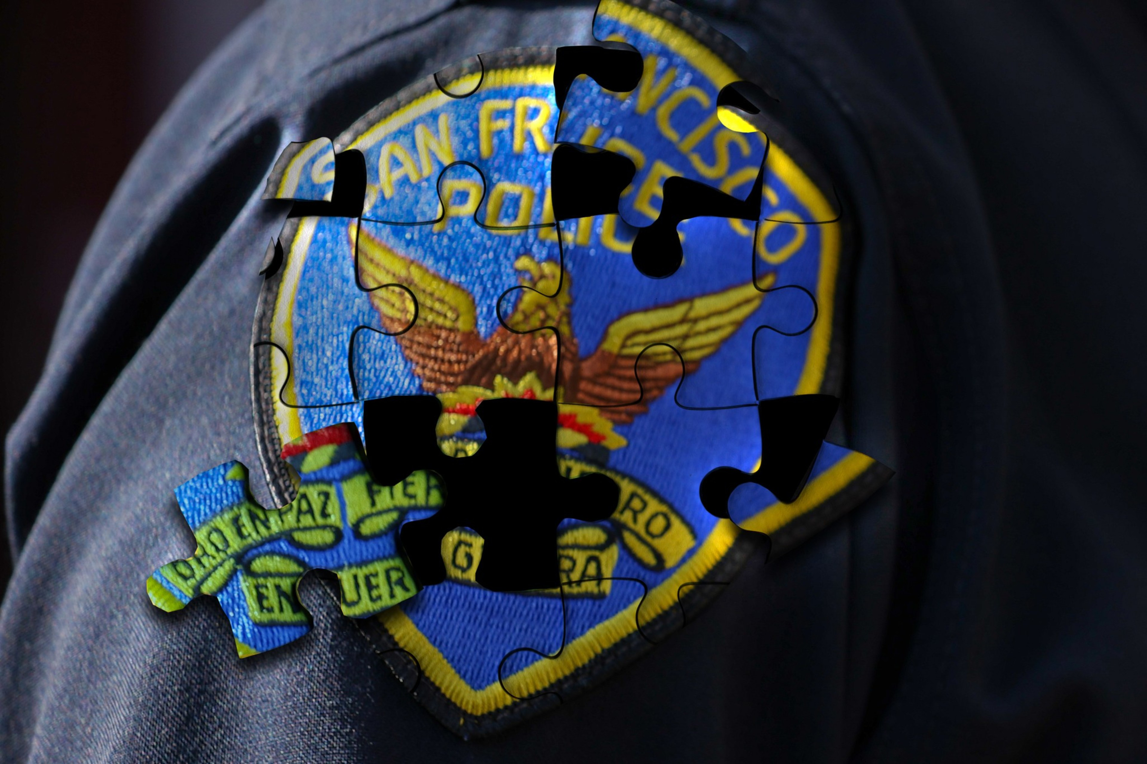 The image depicts the patch of the San Francisco police on a uniform, overlaid with a partially completed jigsaw puzzle, obscuring parts of the patch.