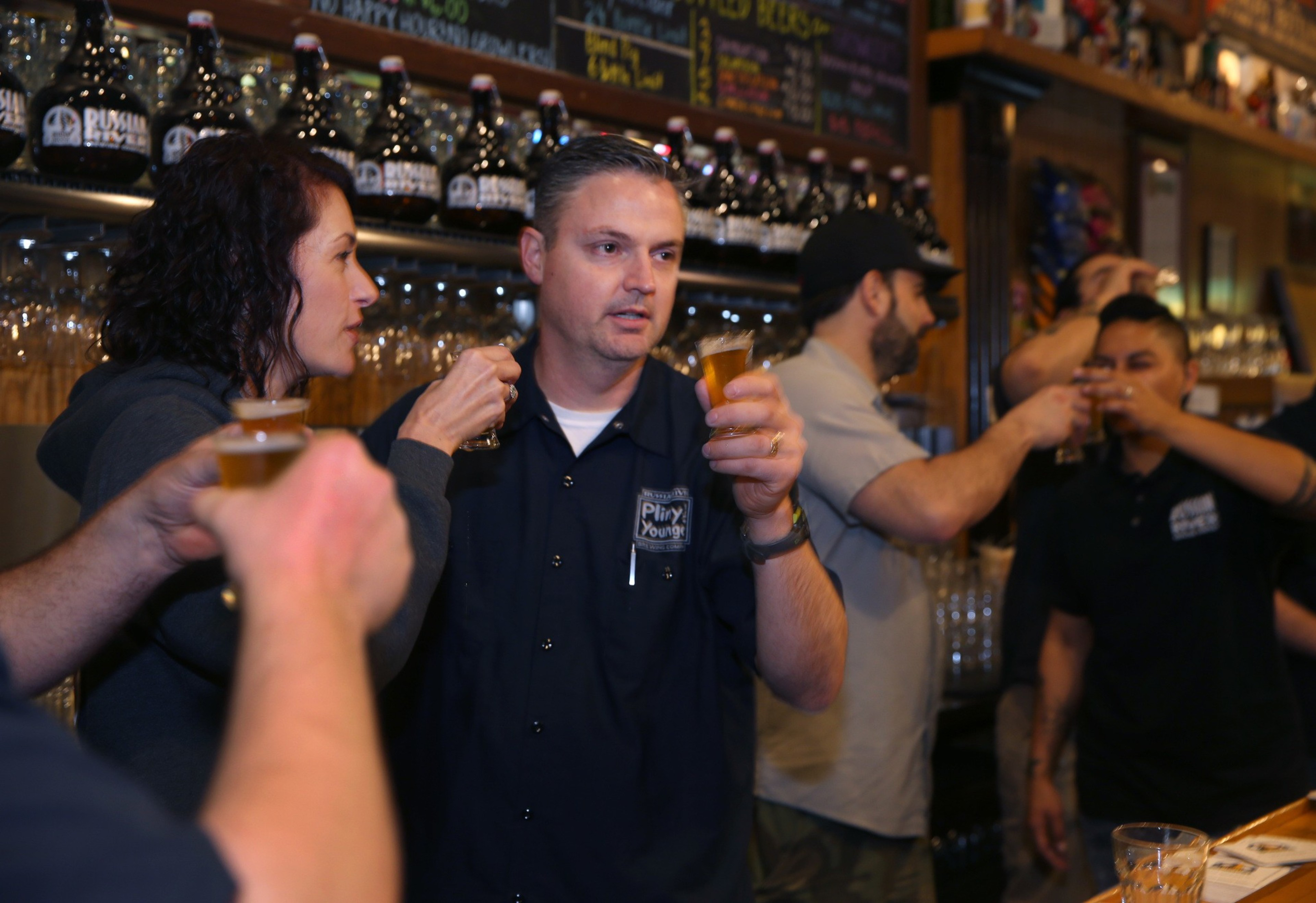 A crowd of beer drinkers gathers in front of a bar. 