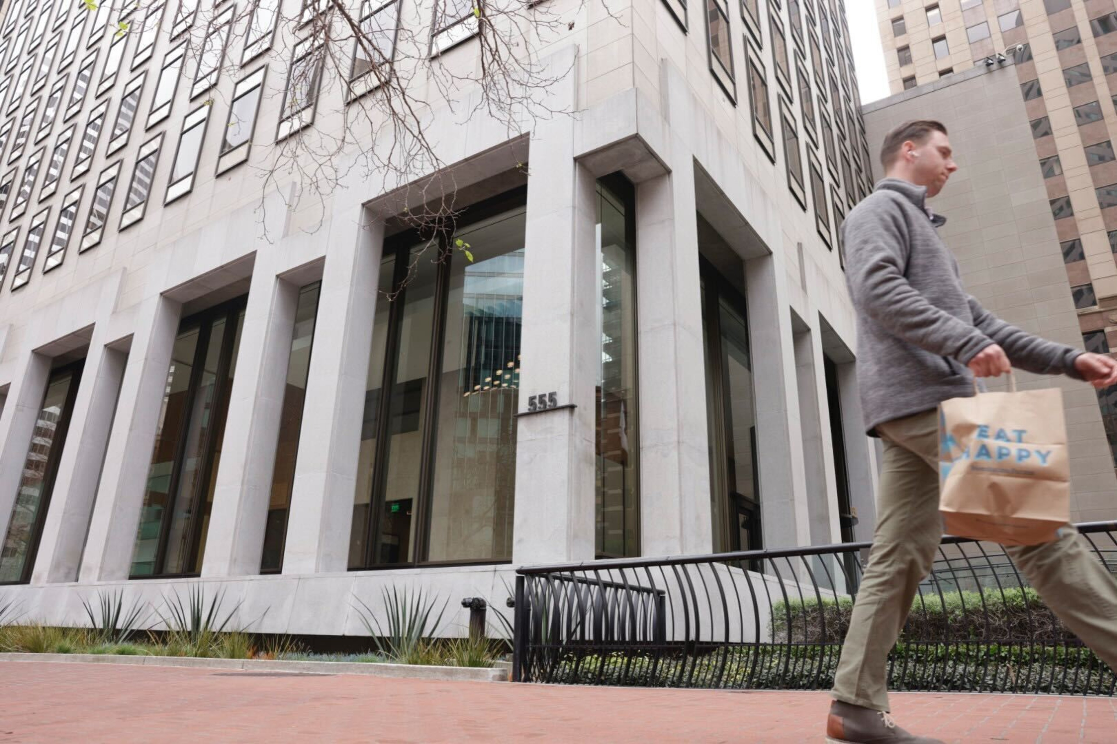 man walks in front of a building