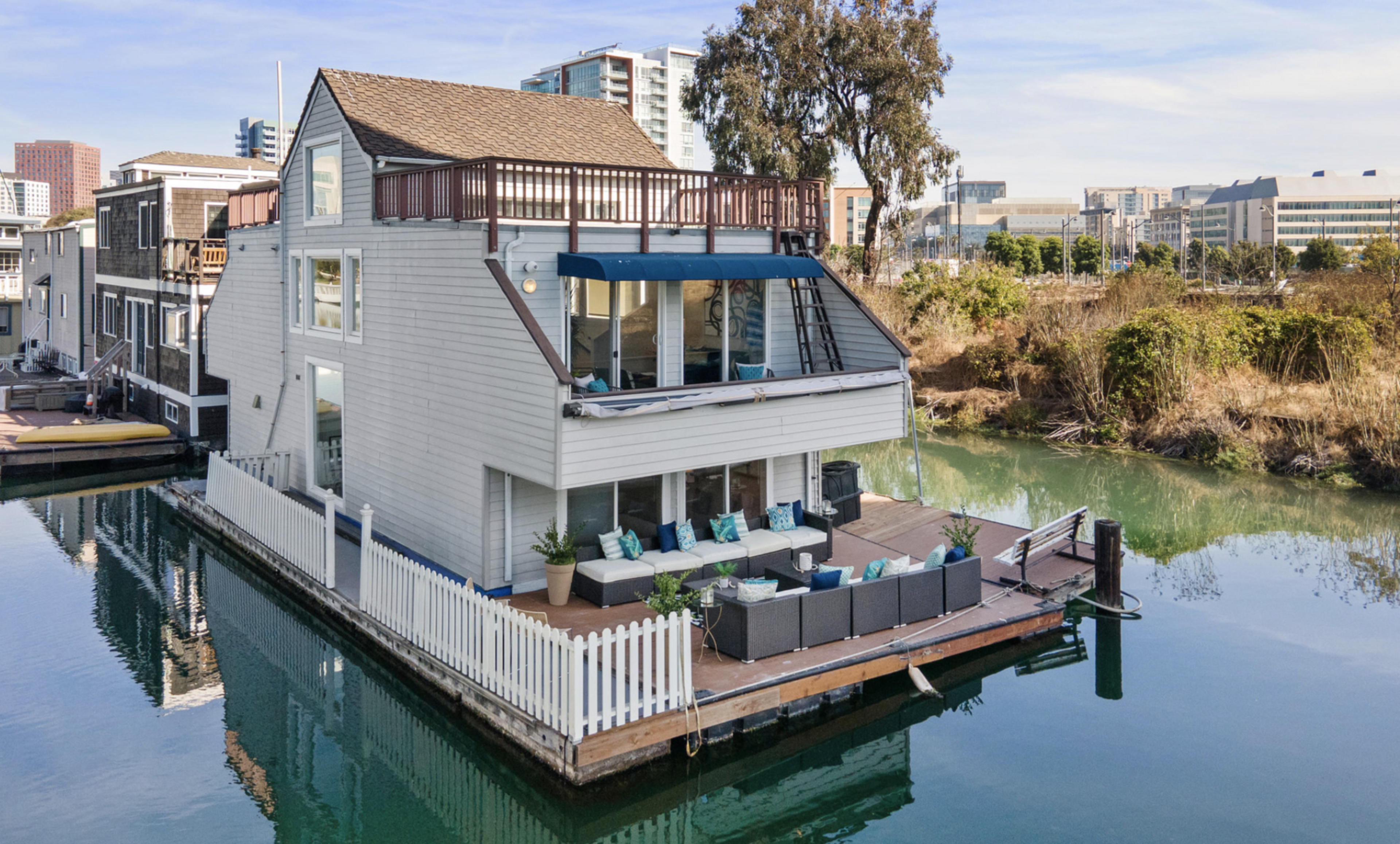 The gray, triangular houseboat at the end of the dock in Mission Creek is shaded by Interstate 280 for part of the afternoon.