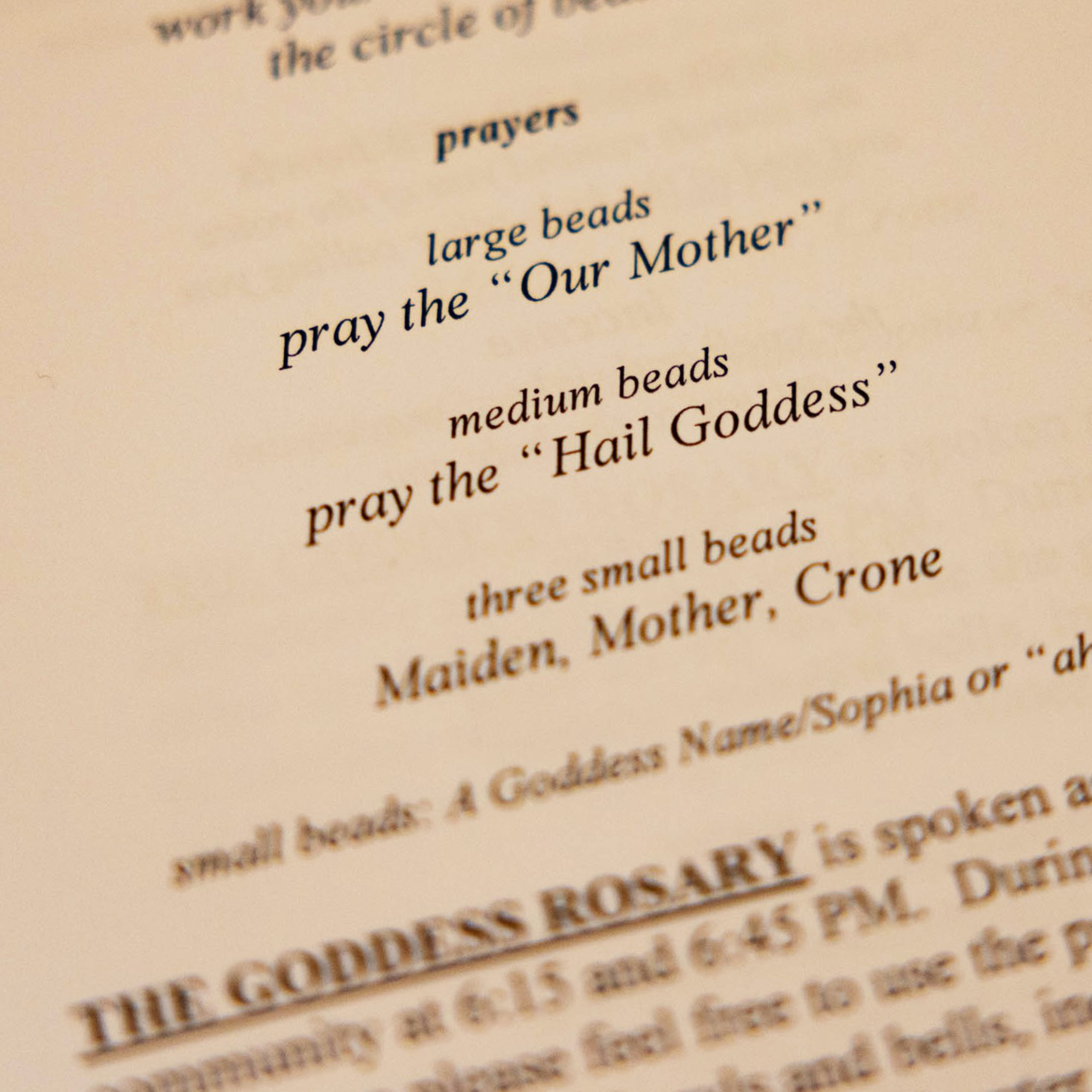 A detail of a church program that read:  Prayers  large beads pray the &quot;Our Mother&quot;  medium beads pray the &quot;Hail Goddess&quot;  three small beads Maiden, Mother, Crone  The Goddess Rosary ...