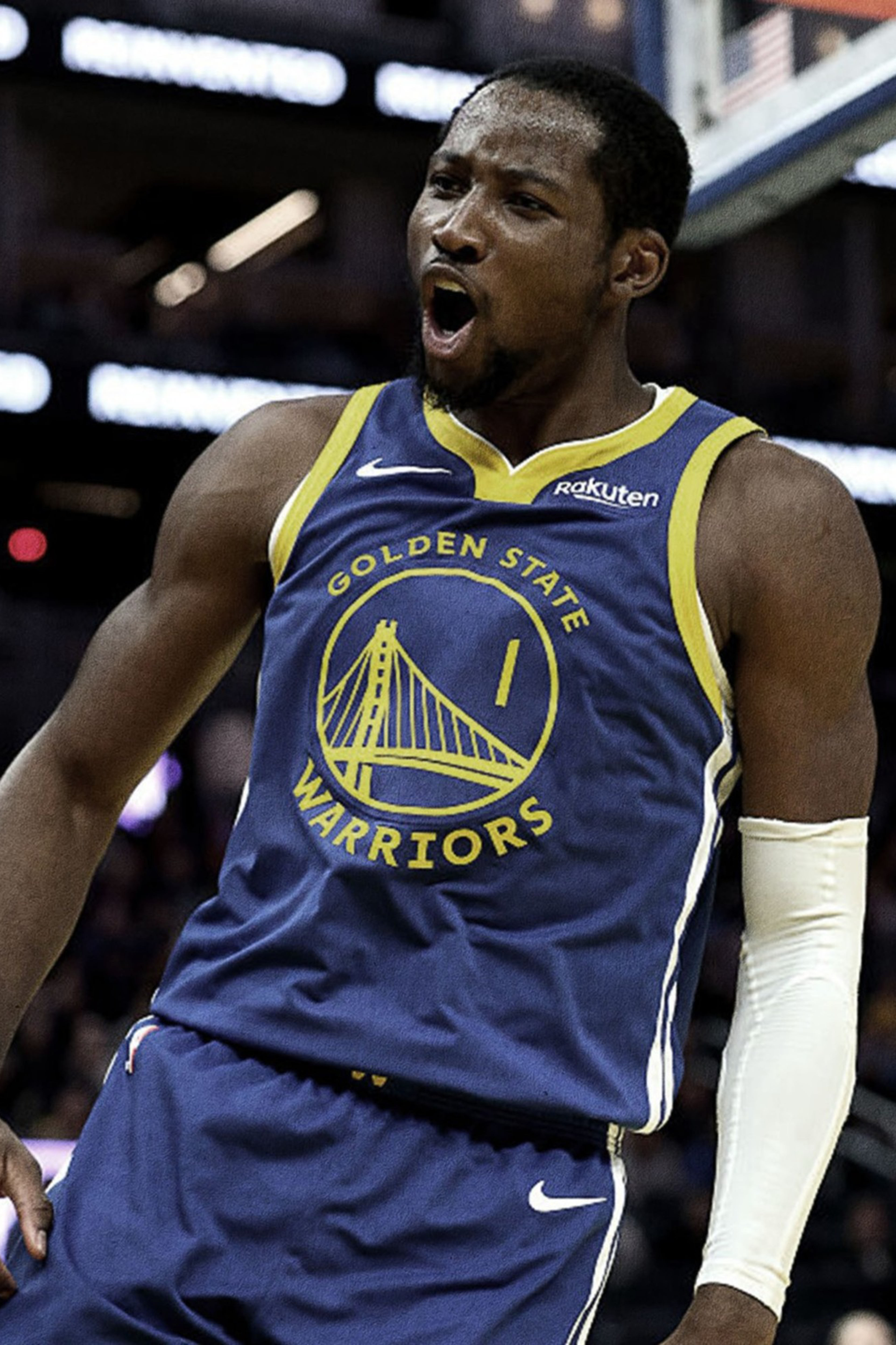 A basketball player in a Golden State Warriors uniform celebrates with mouth open and fist clenched during a game.