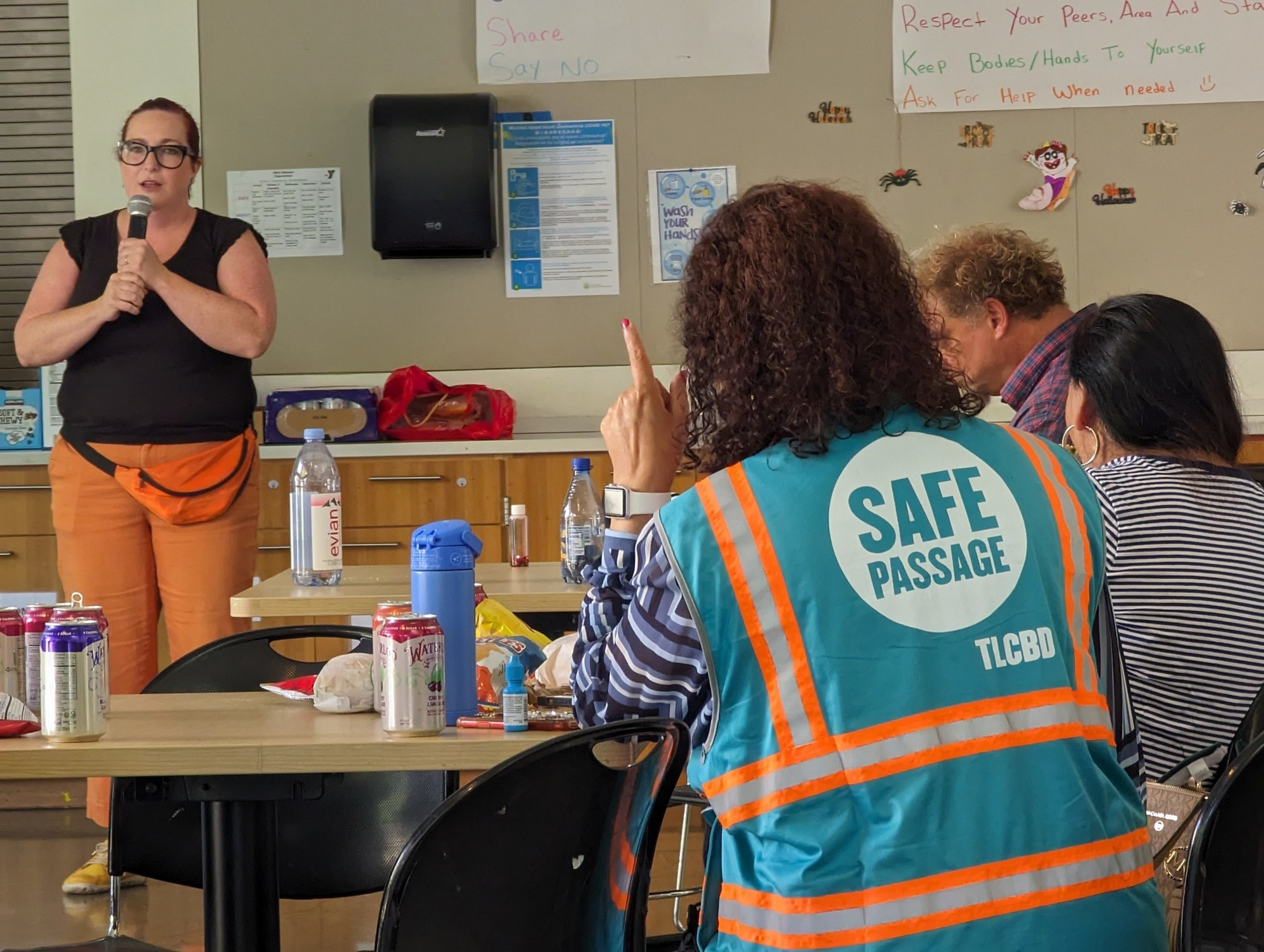 Kate Robinson, executive director for the Tenderloin Community Benefit District, praises former and current "corner captains" at a community gathering at Boeddeker Park's clubhouse in the city's Tenderloin neighborhood Sunday.