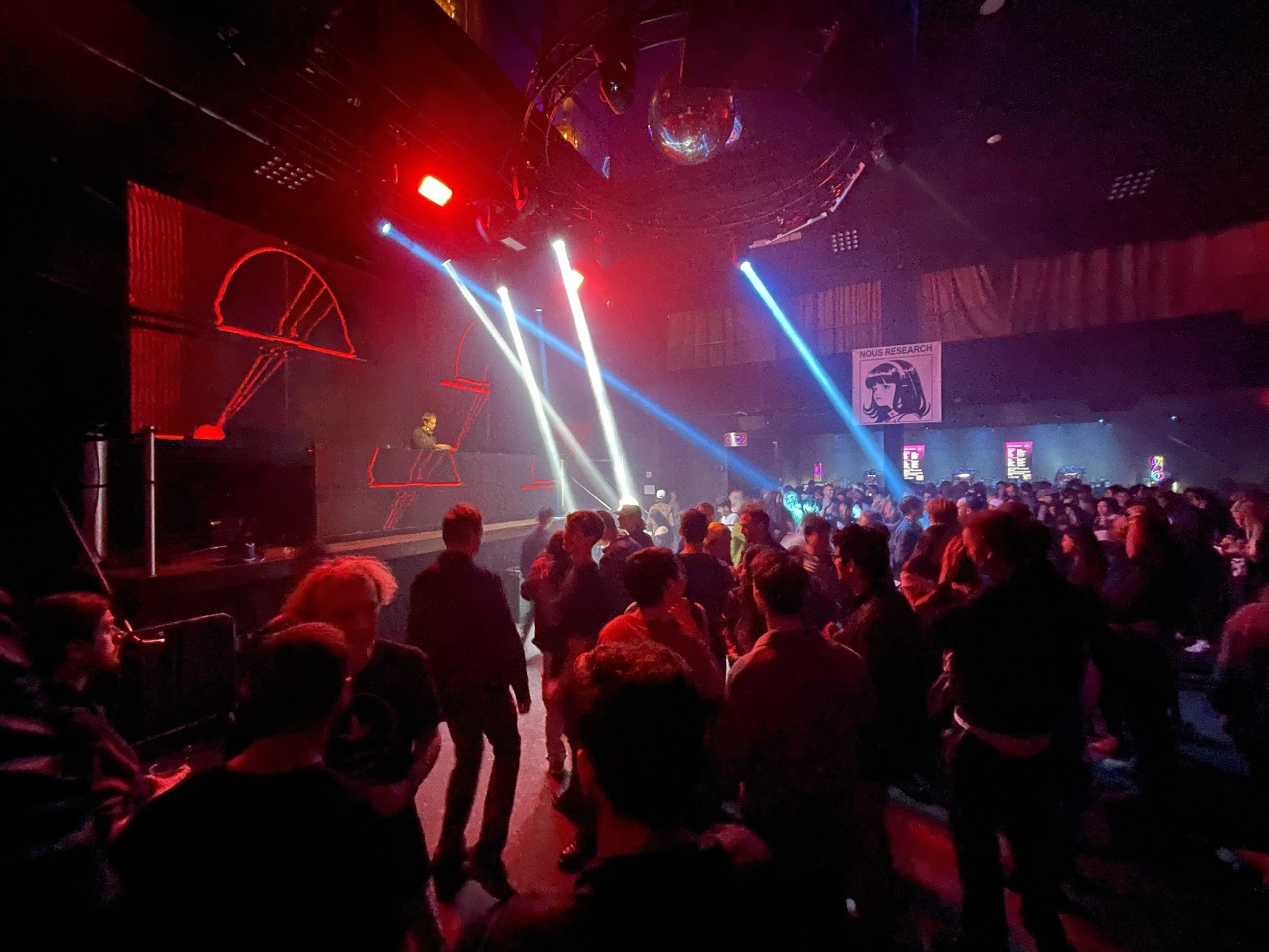 People party inside a dark nightclub.