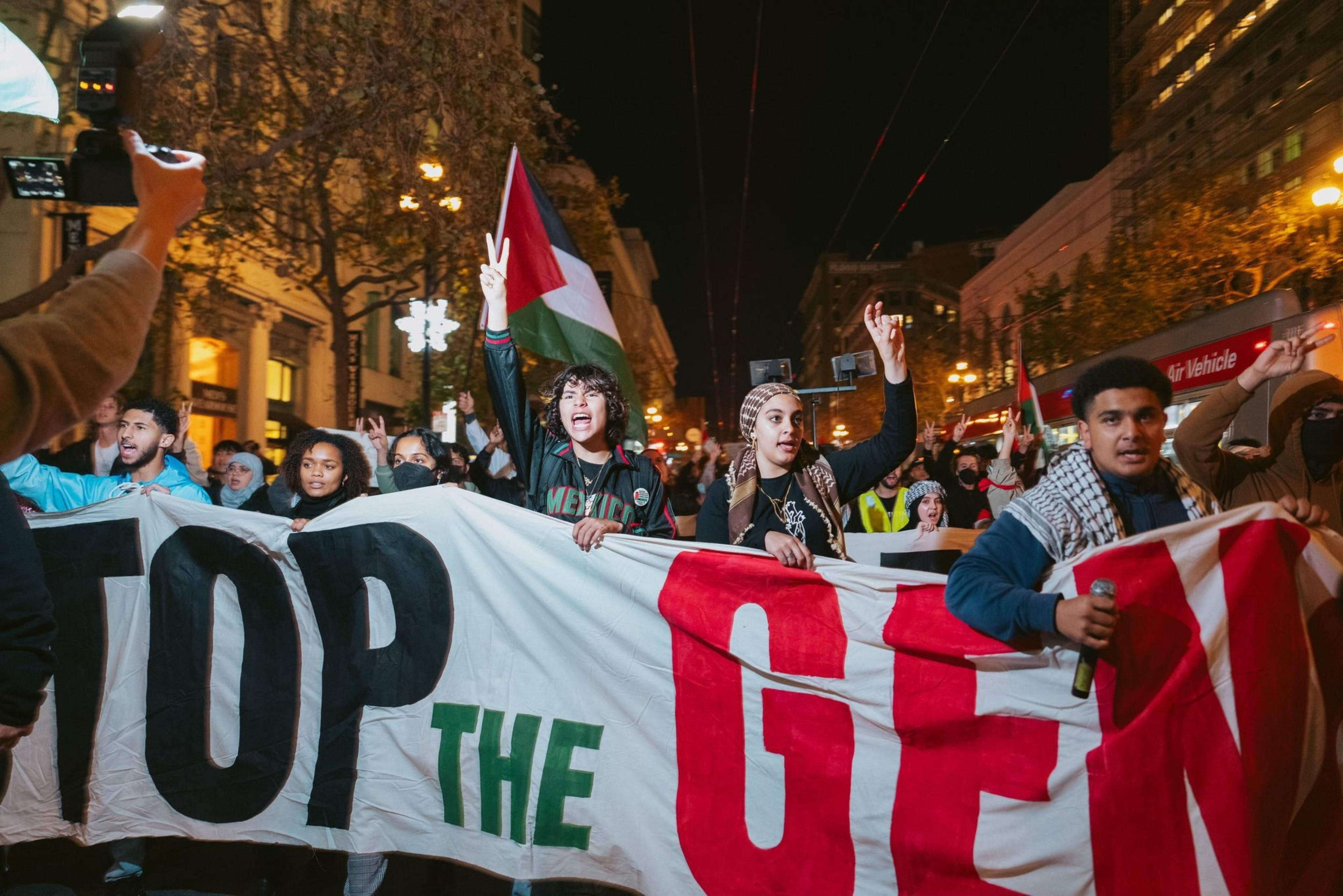 Protesters carry a banner that reads, &quot;Stop the Genocide.&quot;