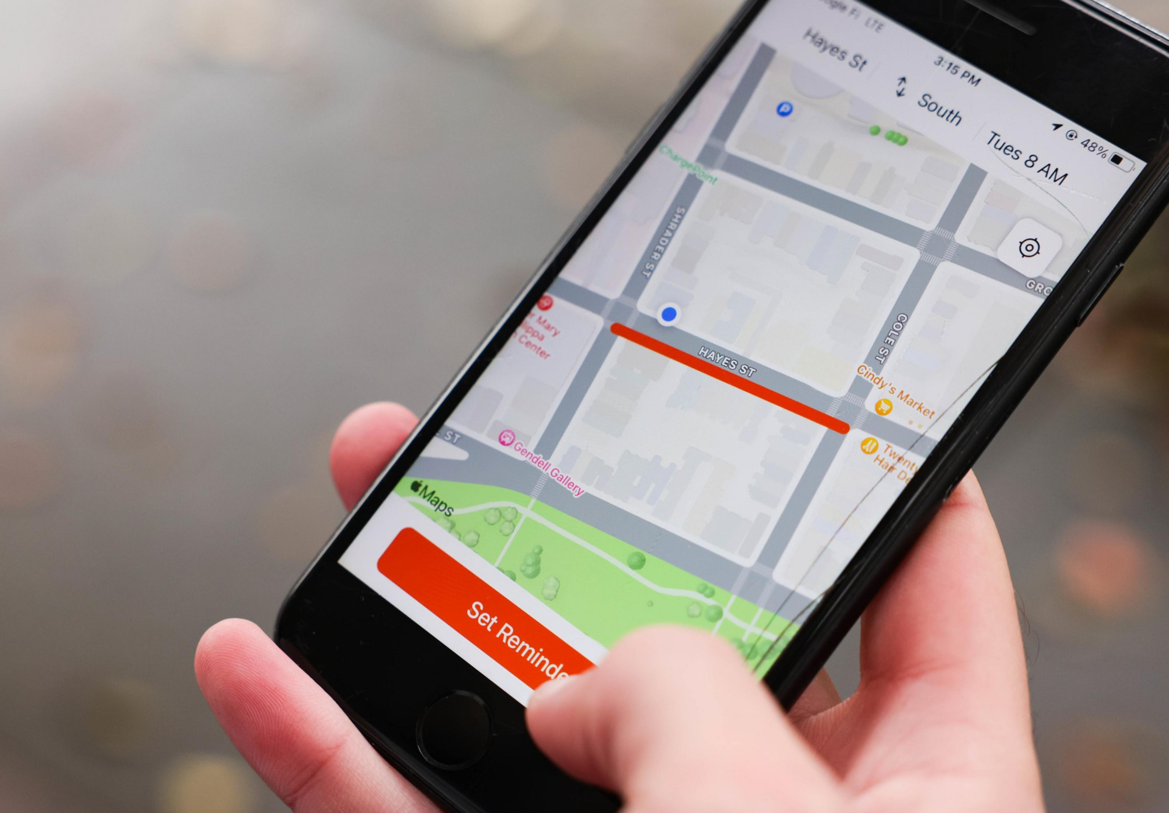 A person holds a phone with a map open on its screen.