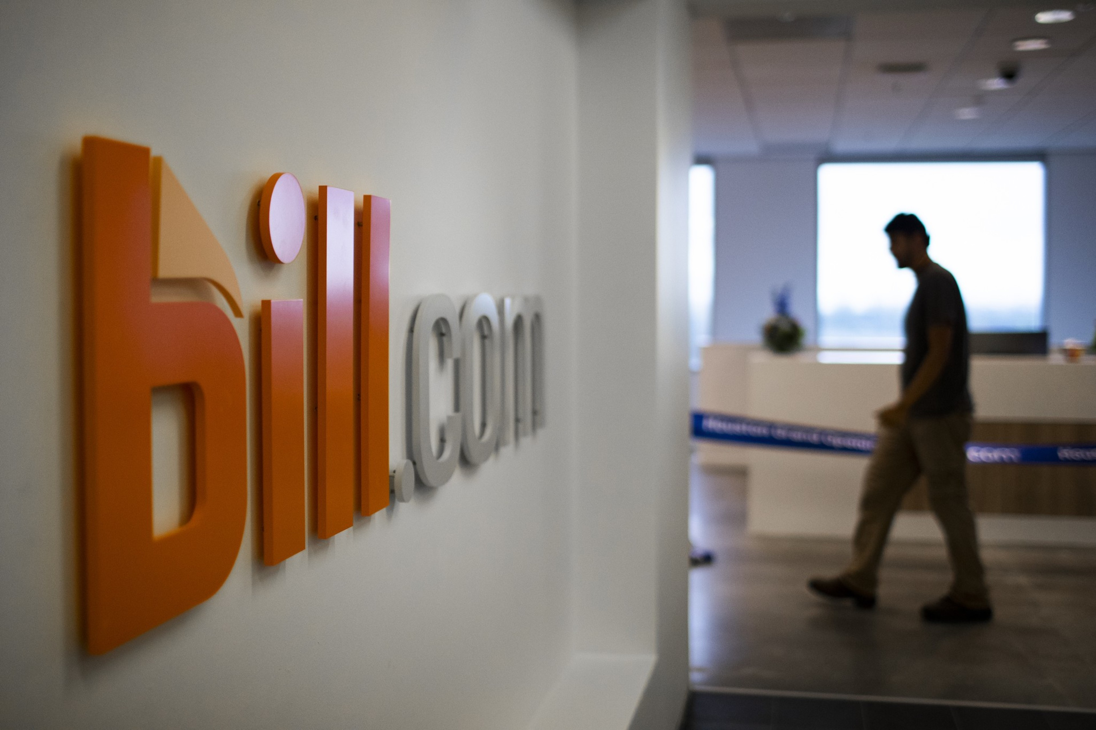 Bill's former logo is seen in its Houston offices. A shadowed person can be seen walking in the right side of the image.