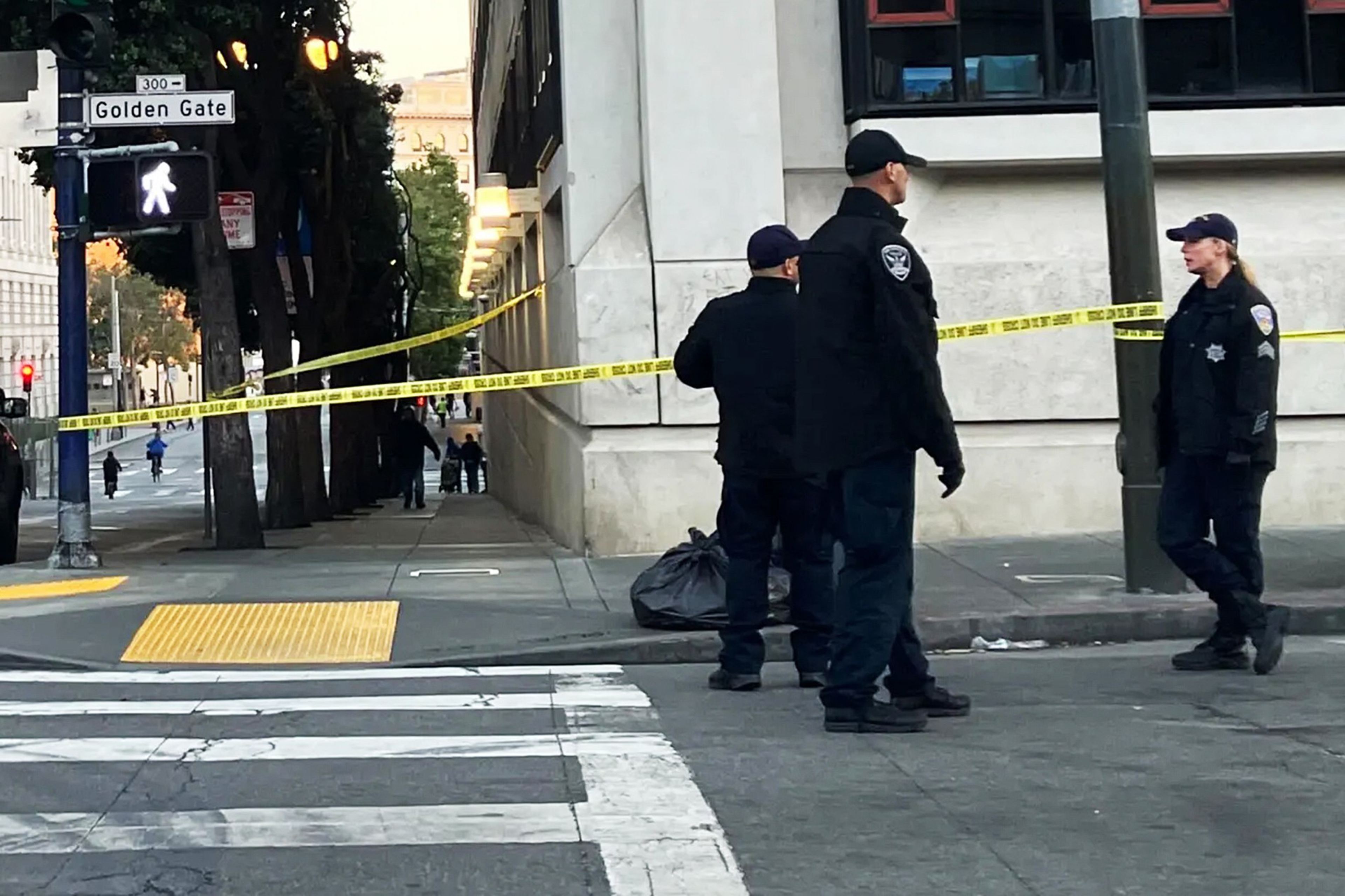 Officers stand around a shooting scene in the Tenderloin.
