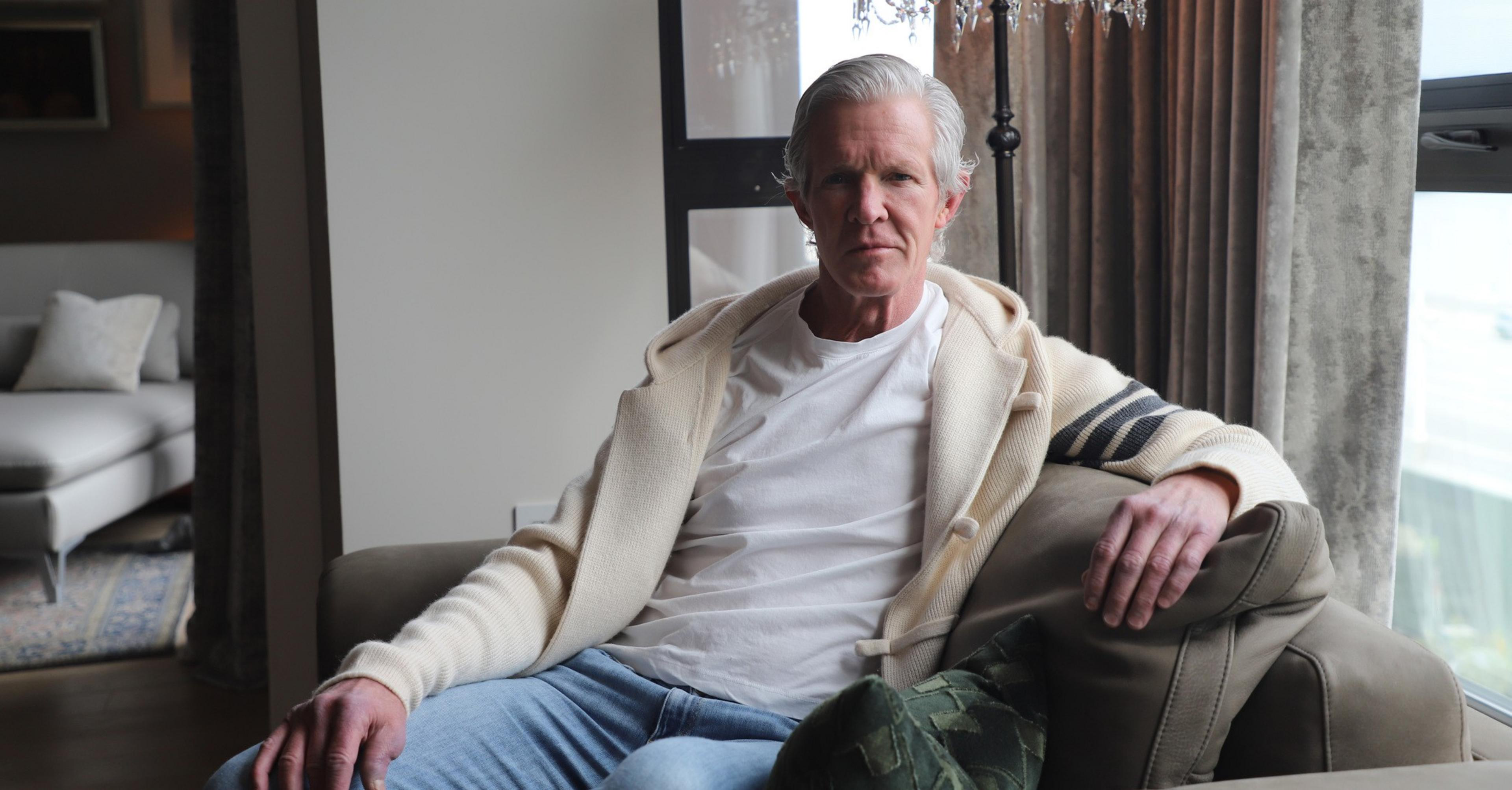 A man sits inside a fancy condo.