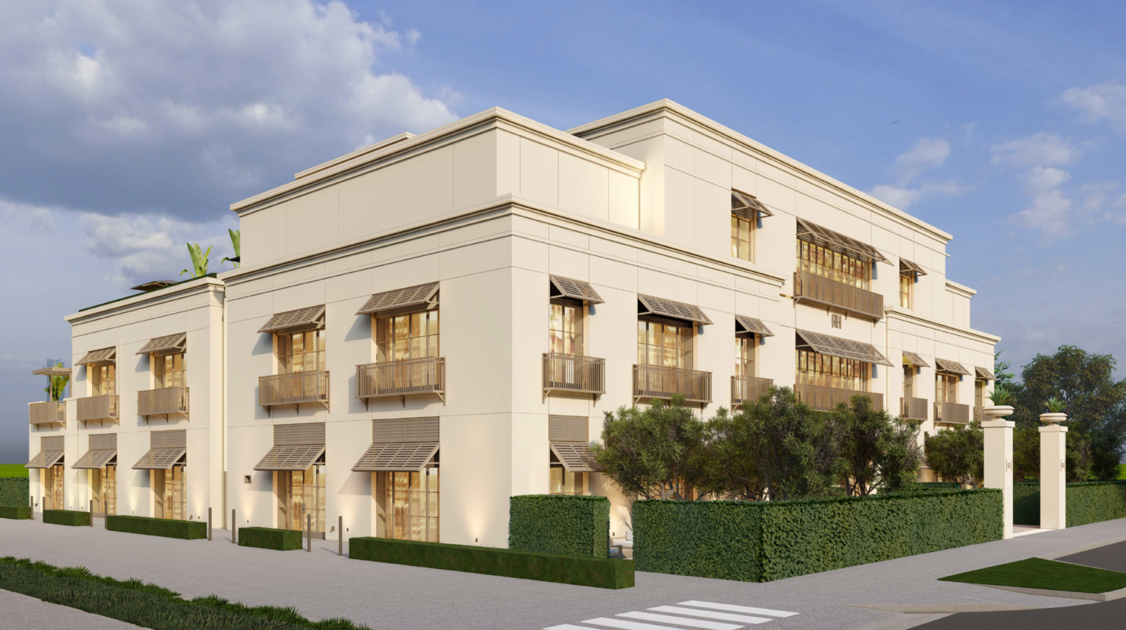 A modern, white three-story building with large windows and balconies, surrounded by neatly trimmed green hedges and trees under a partly cloudy sky.