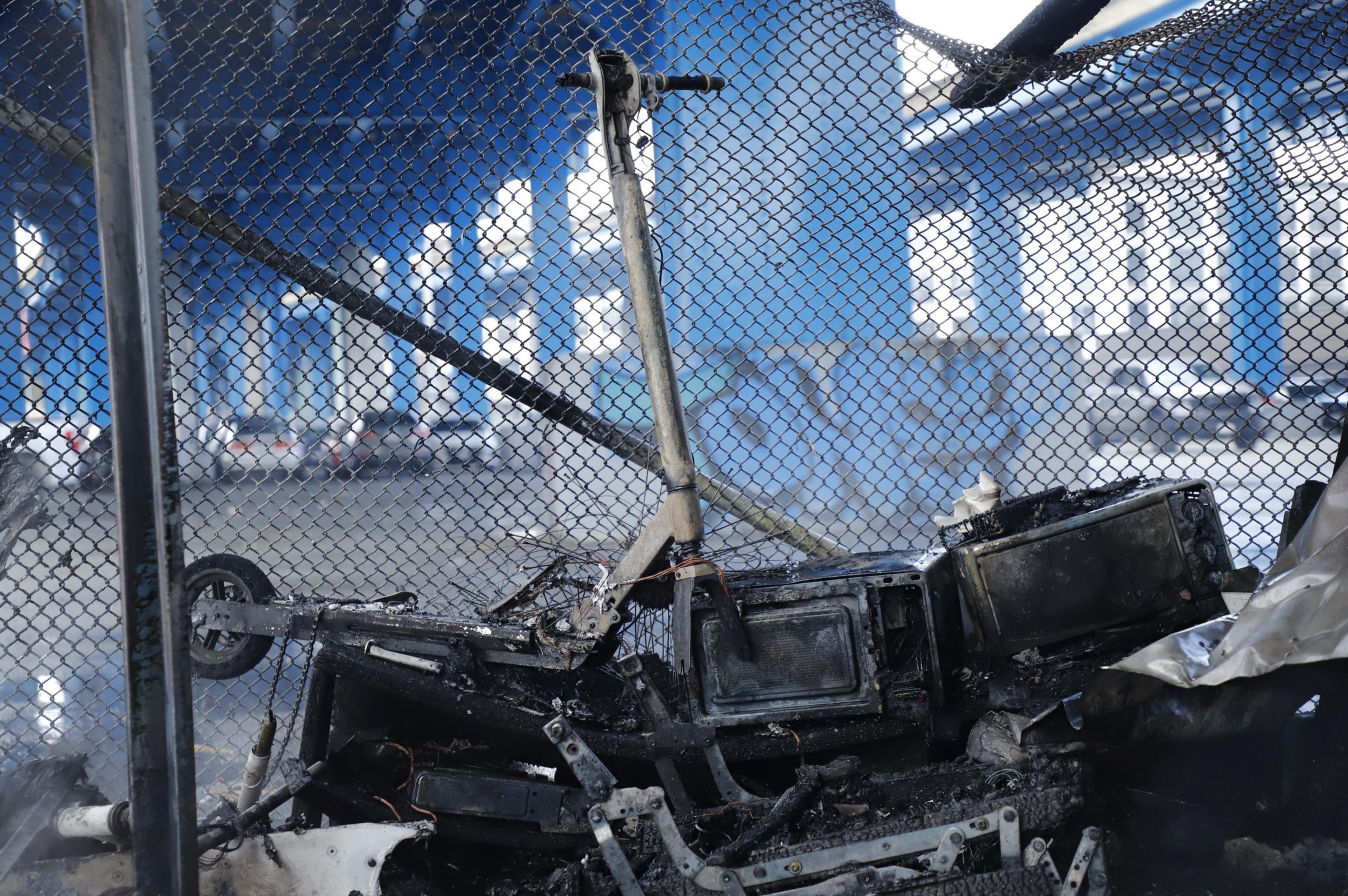 A remains of a scooter, microwave other items following a fire in a homeless encampment in a CalTrans parking lot on Division Street.