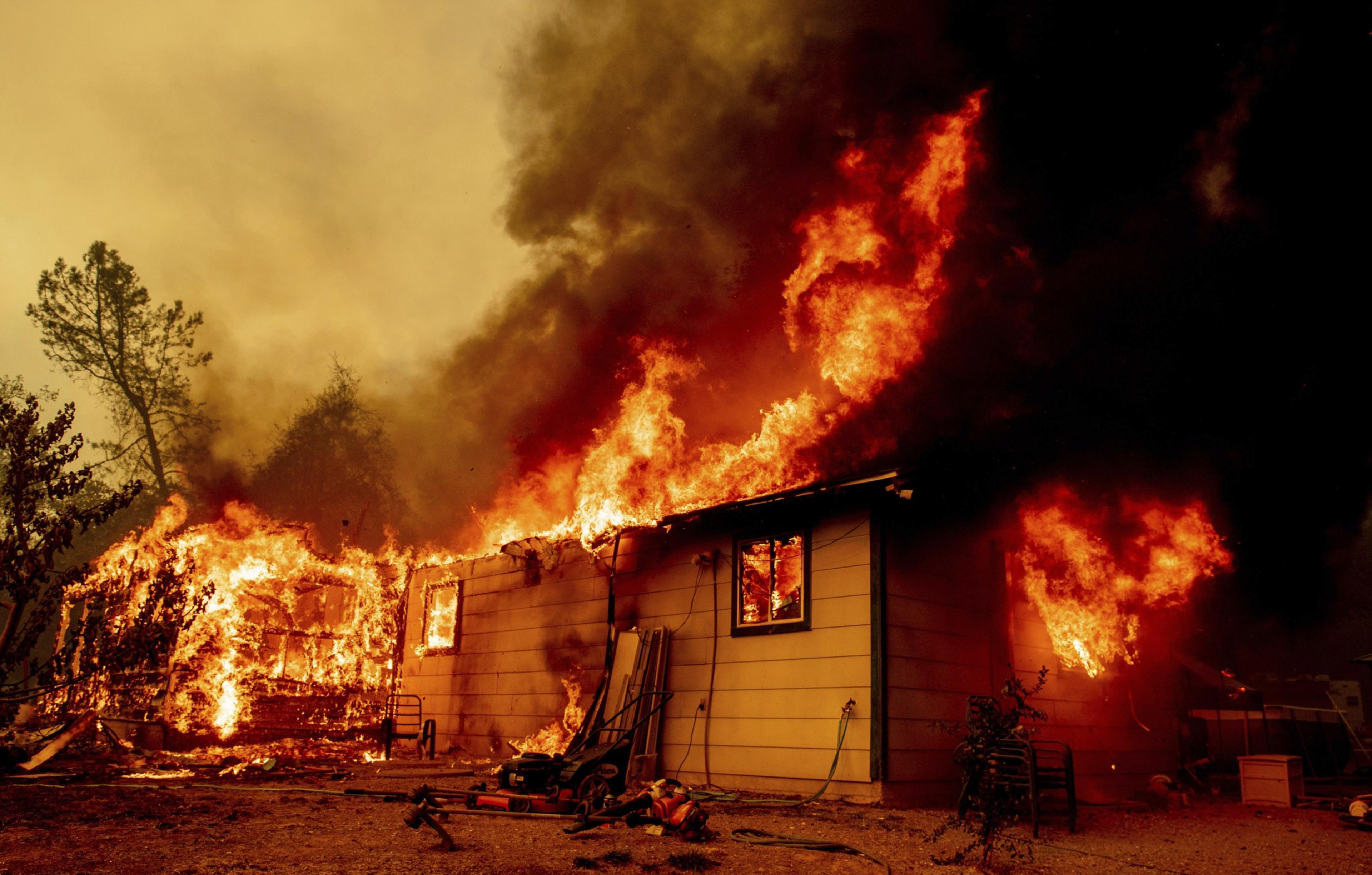 A house on fire with orange skies in the background.