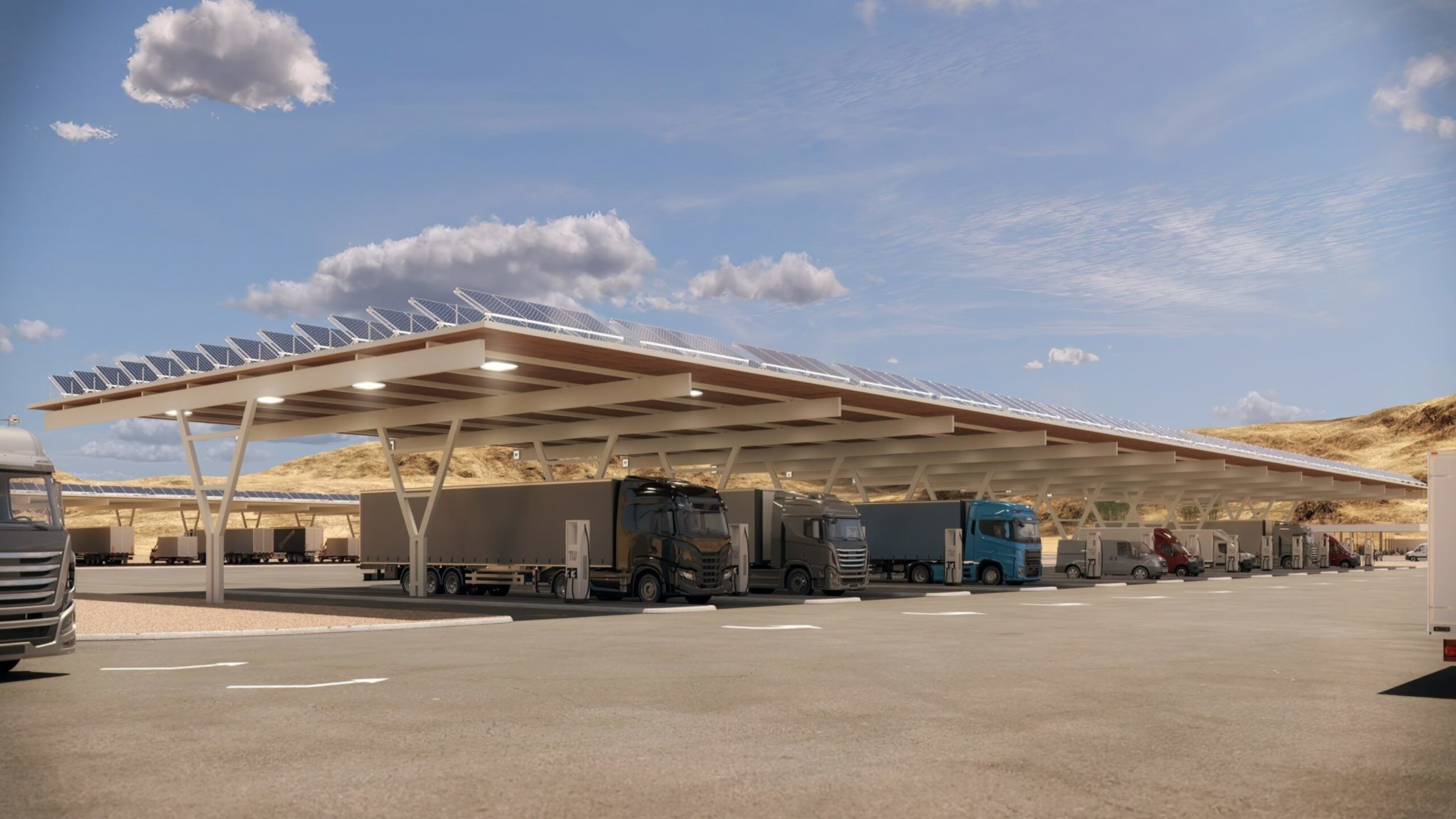 A solar panel-covered truck charging station with multiple trucks parked underneath and a clear blue sky with scattered clouds.