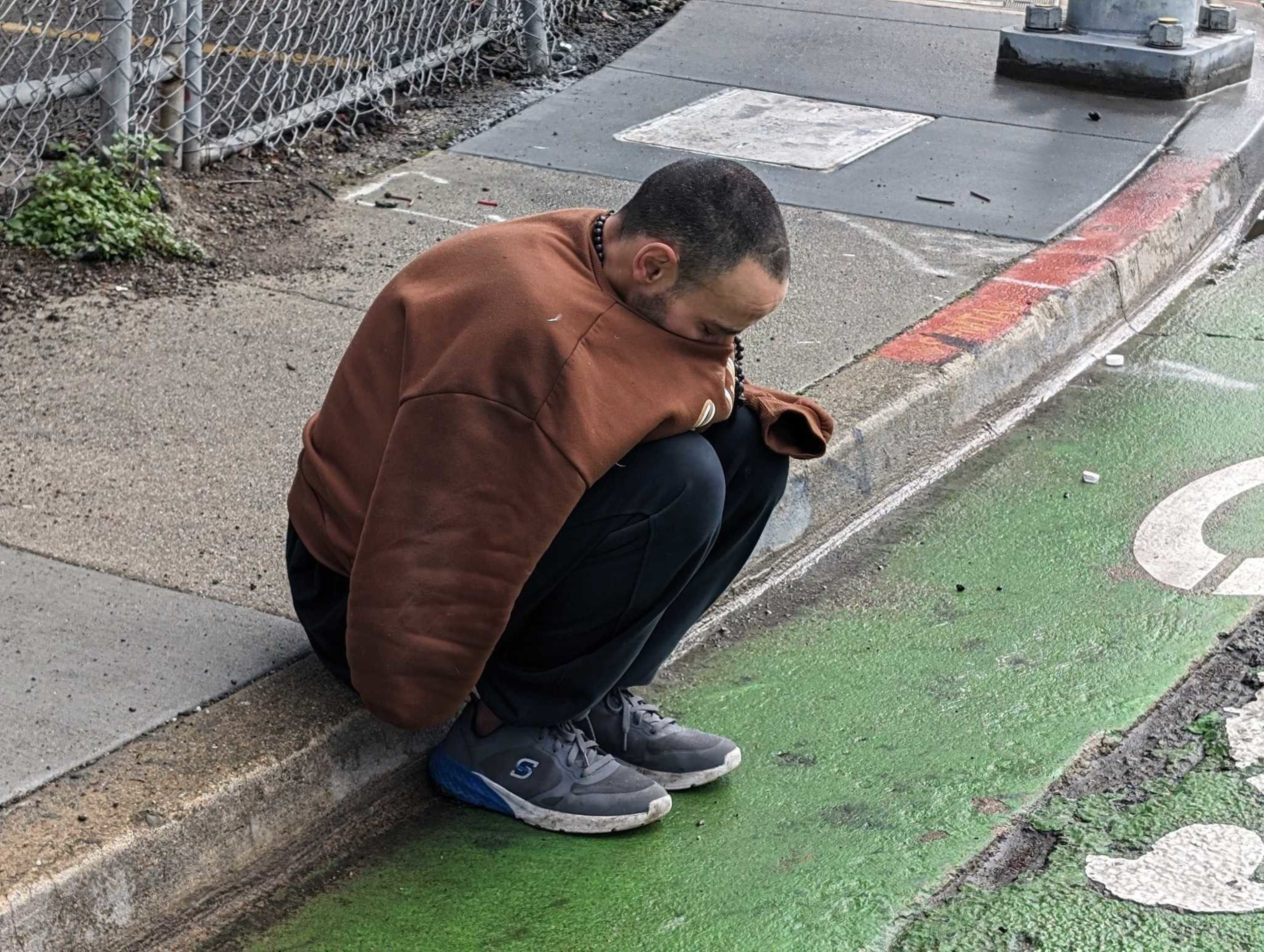 man sobs on curb