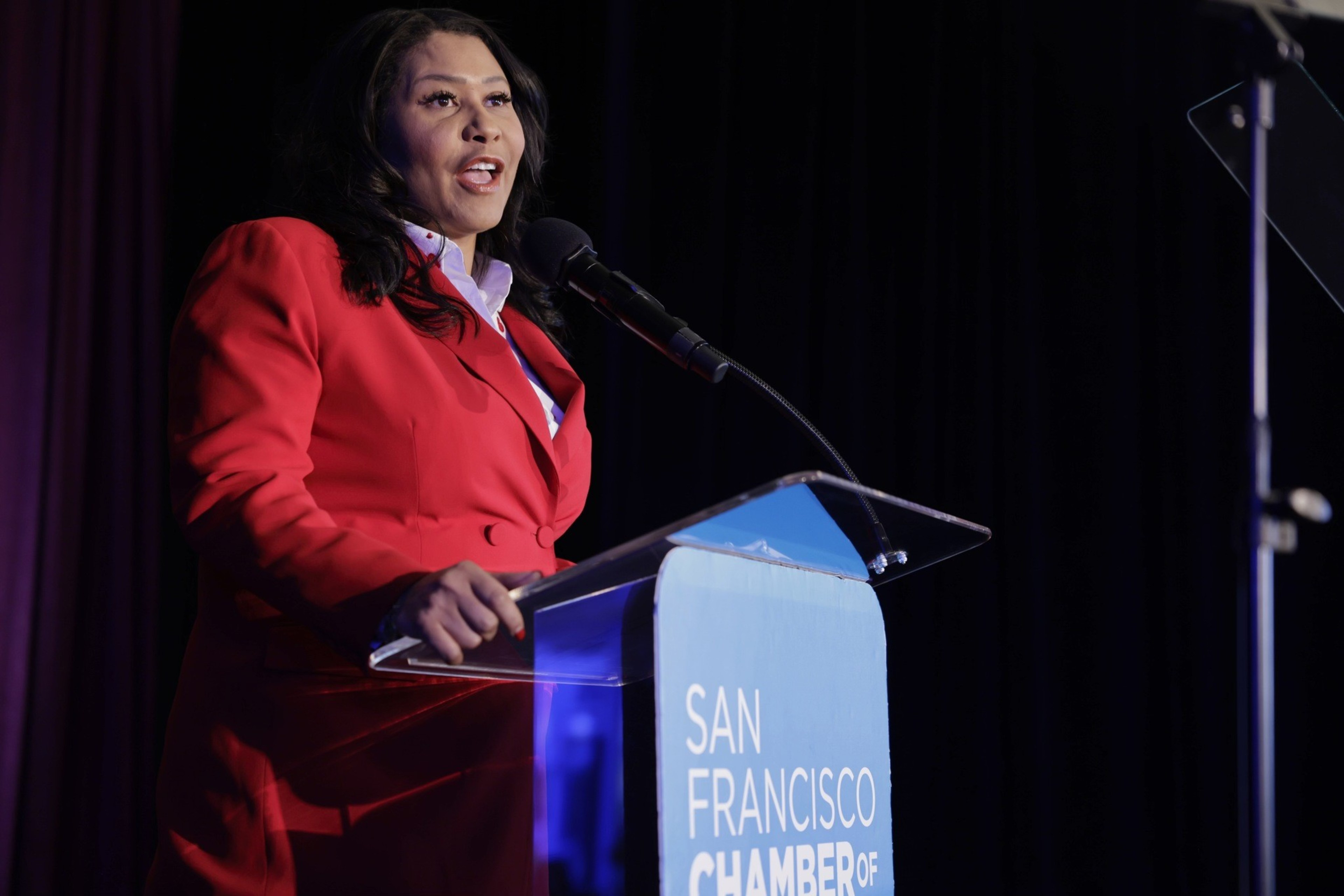 woman at podium in red pantsuit