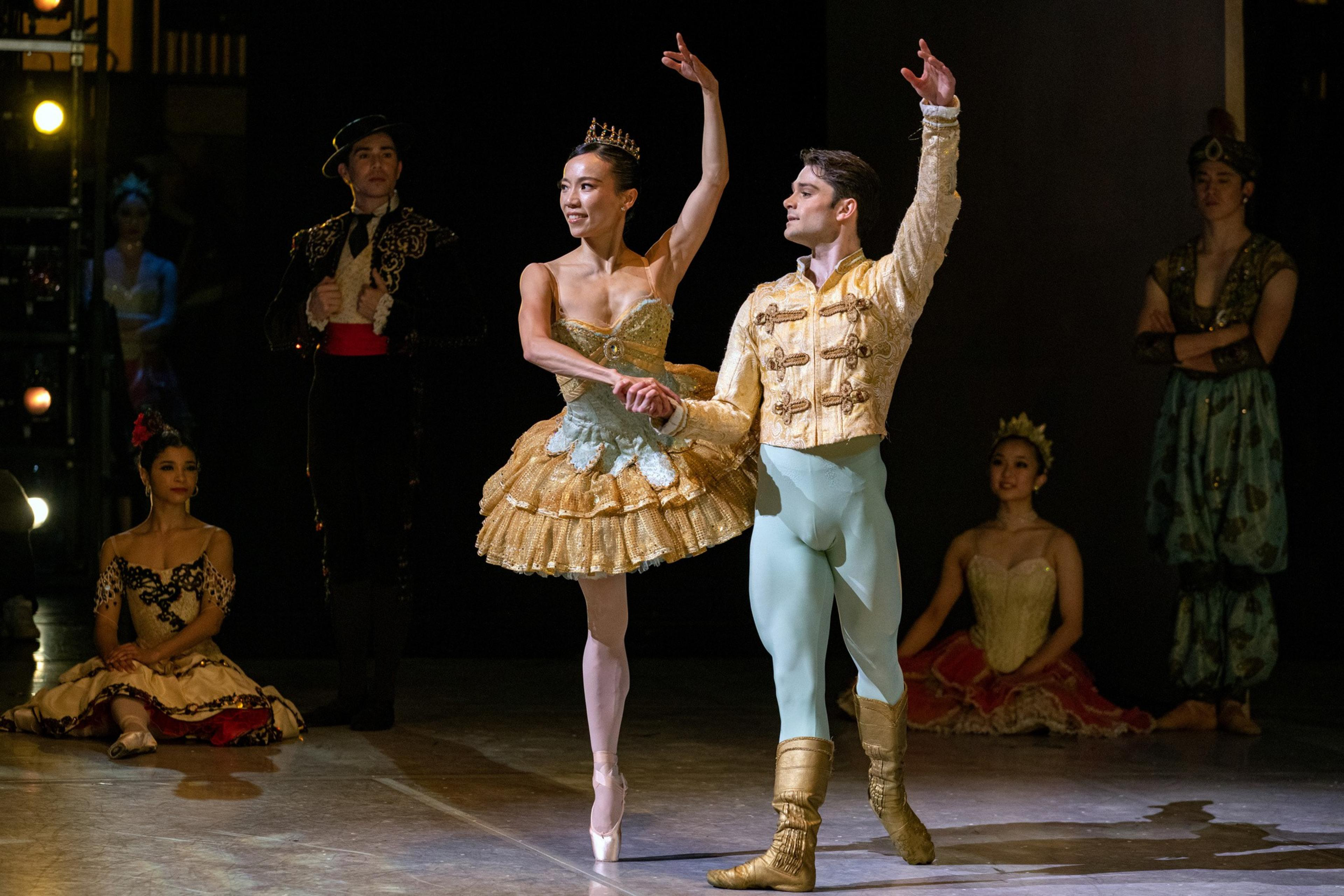 Two people dancing onstage with people observing off stage.