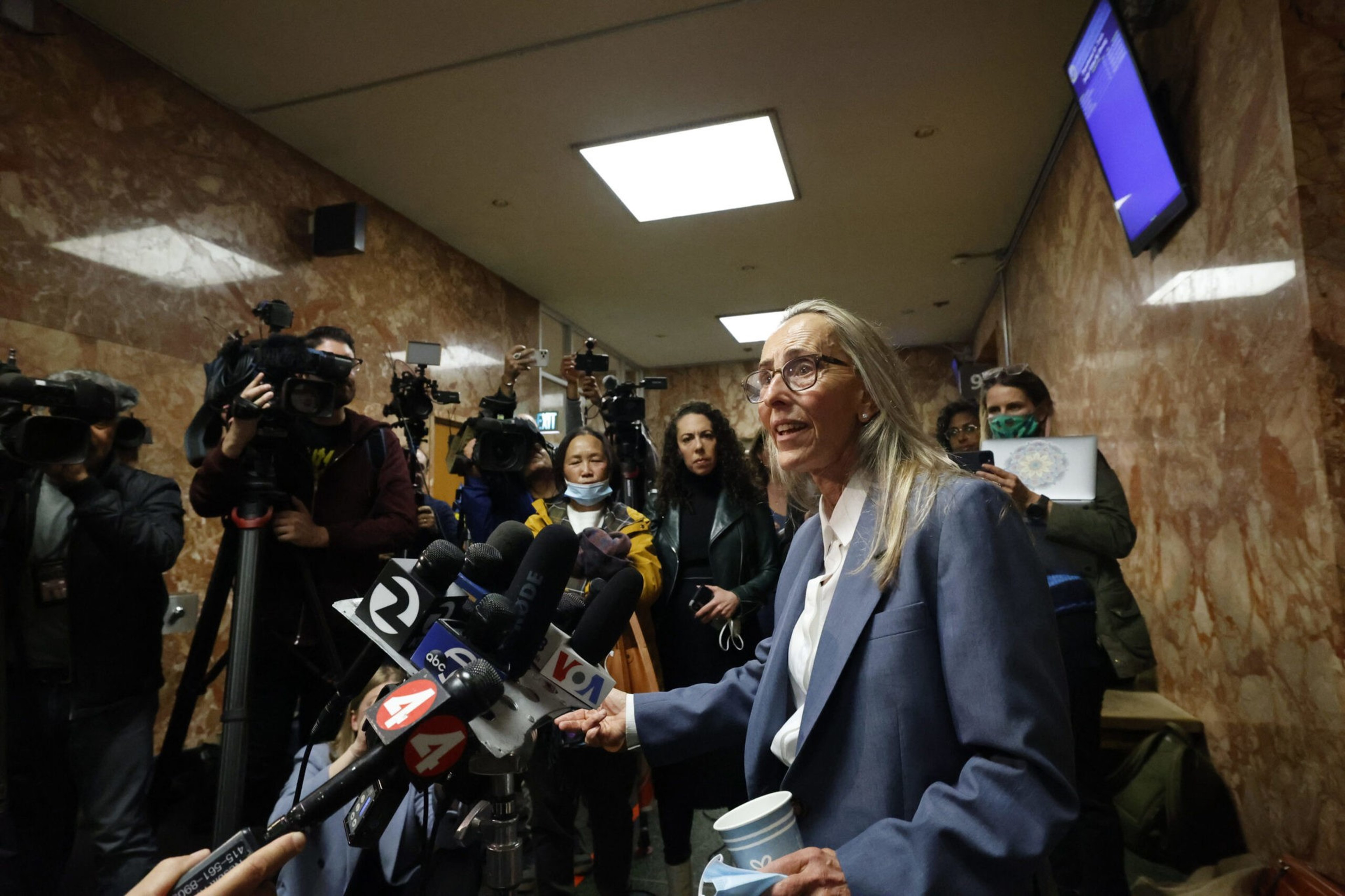 A woman speaks to reporters.