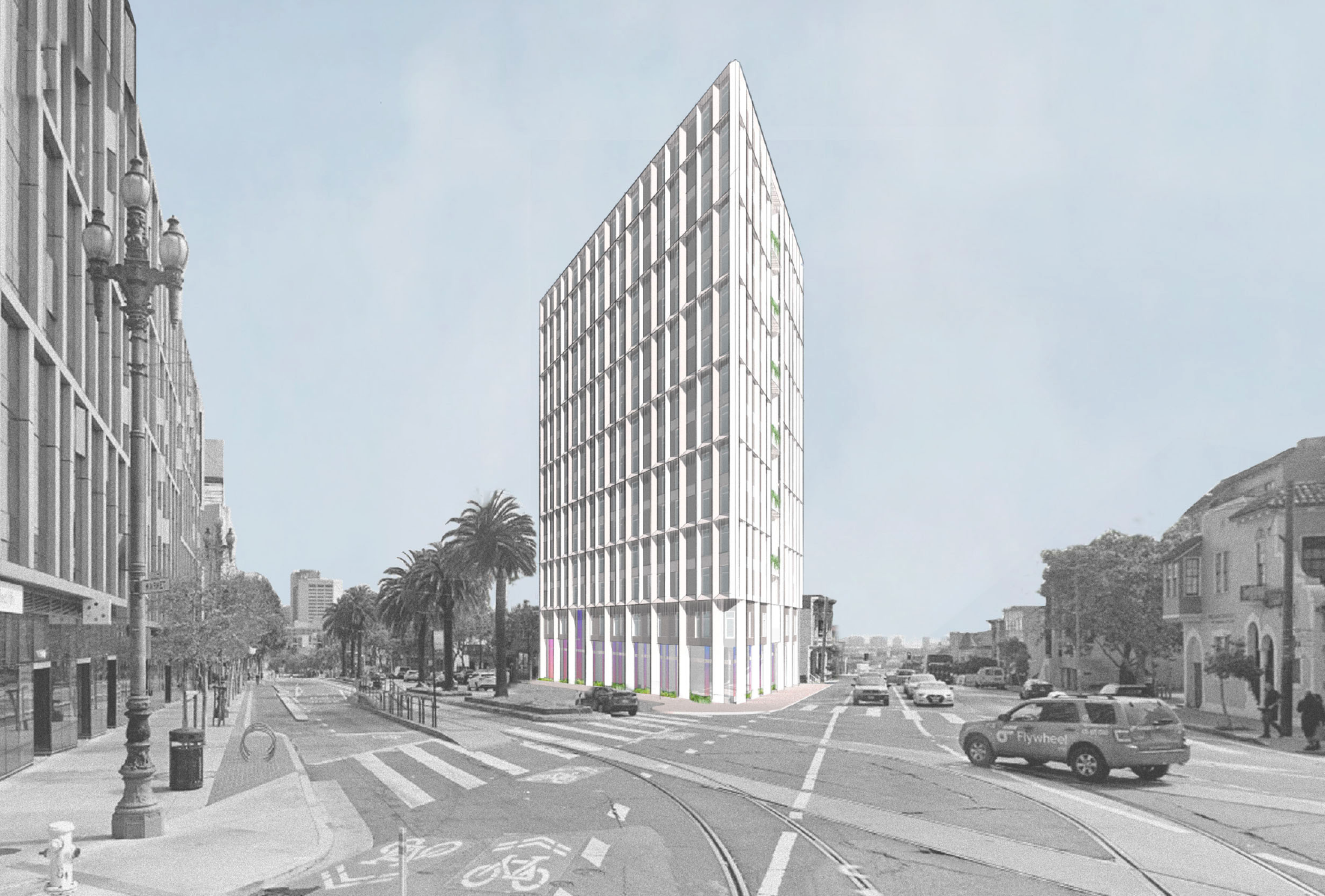 A tall, rectangular, modern building stands at an intersection with palm trees lining the street and several cars driving on the wide roads nearby.