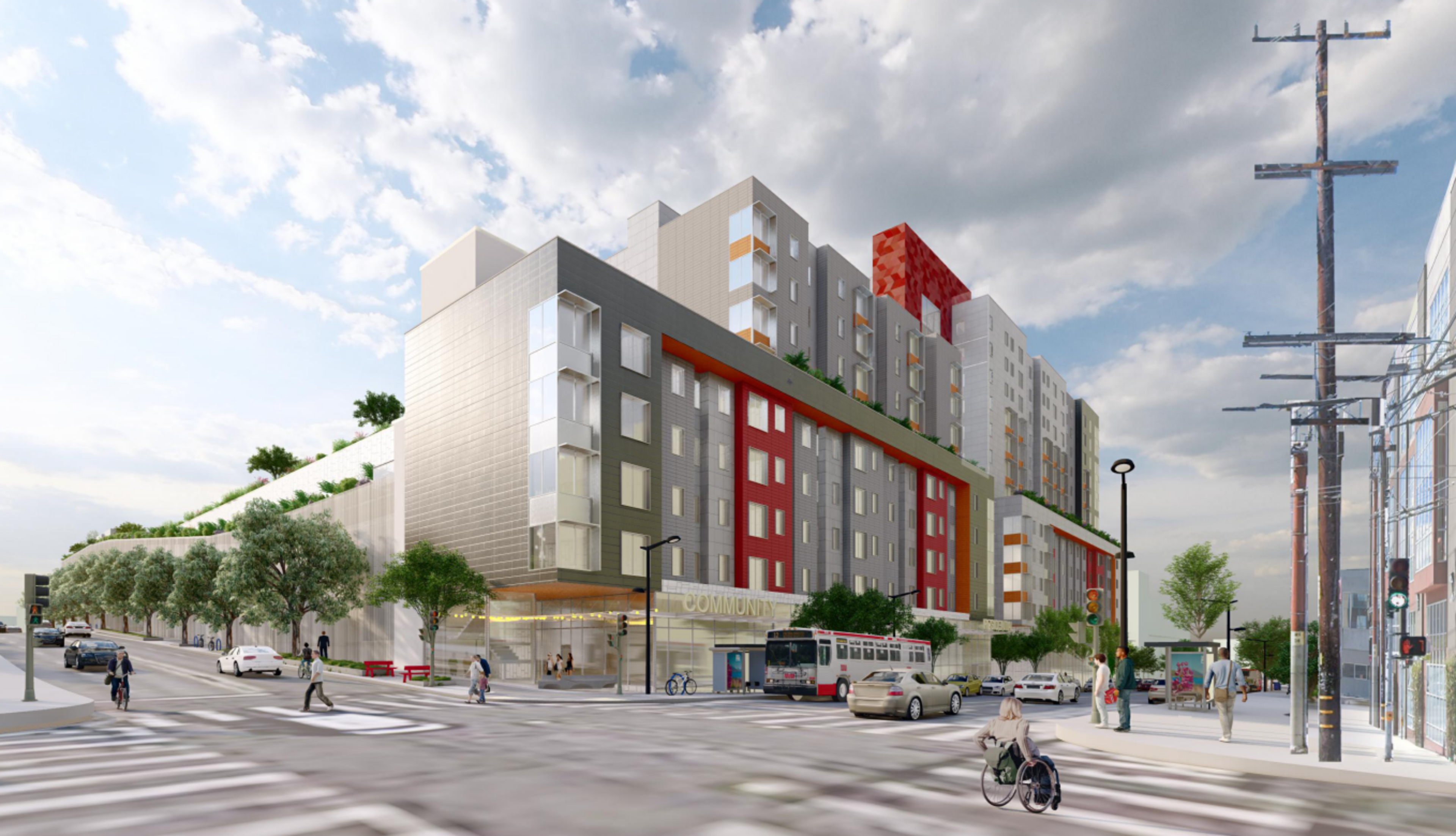 A modern, multi-story building with gray and red accents sits at a busy intersection with pedestrians, cars, a bus, trees, and power lines.
