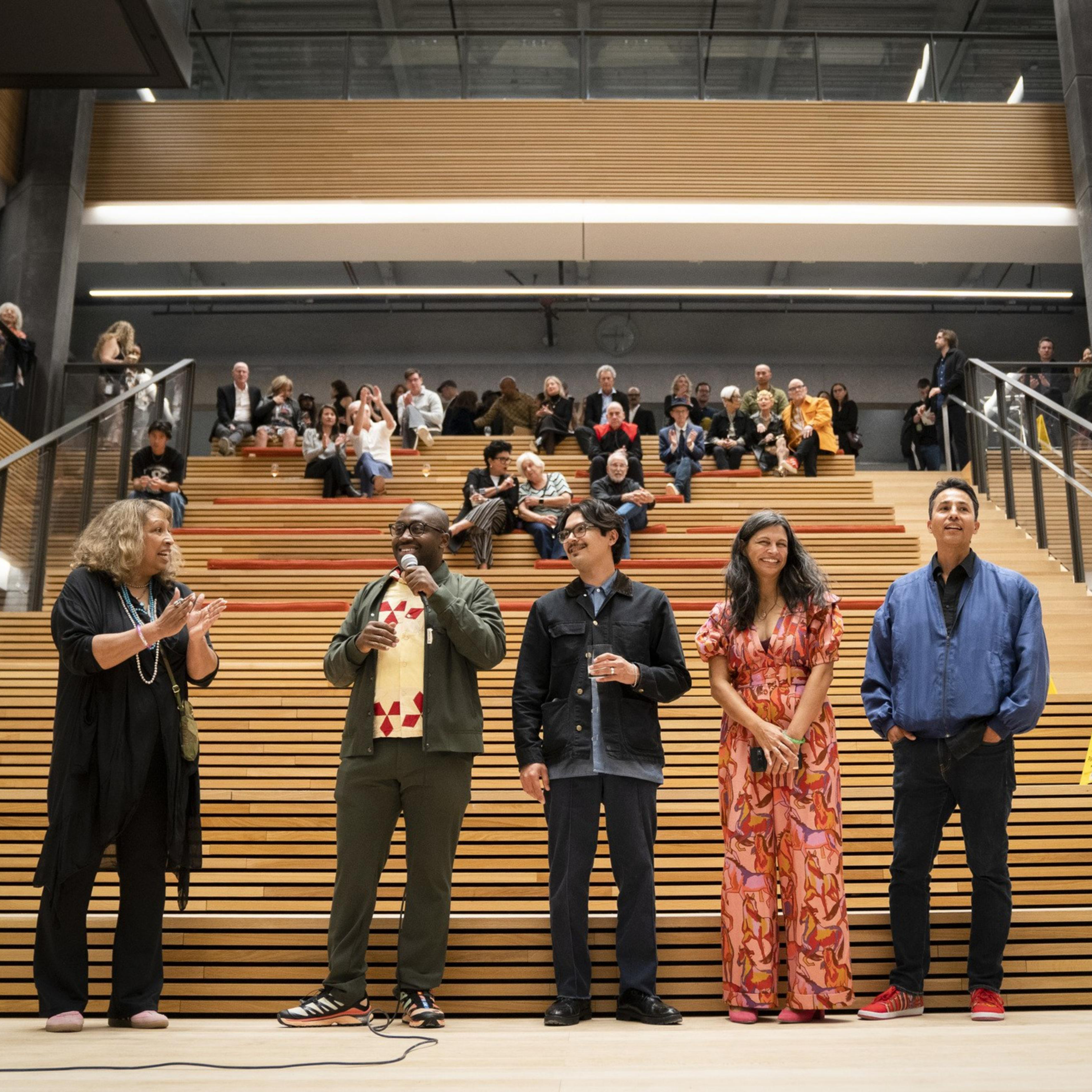 Five people stand at the bottom of cantilever stairs.