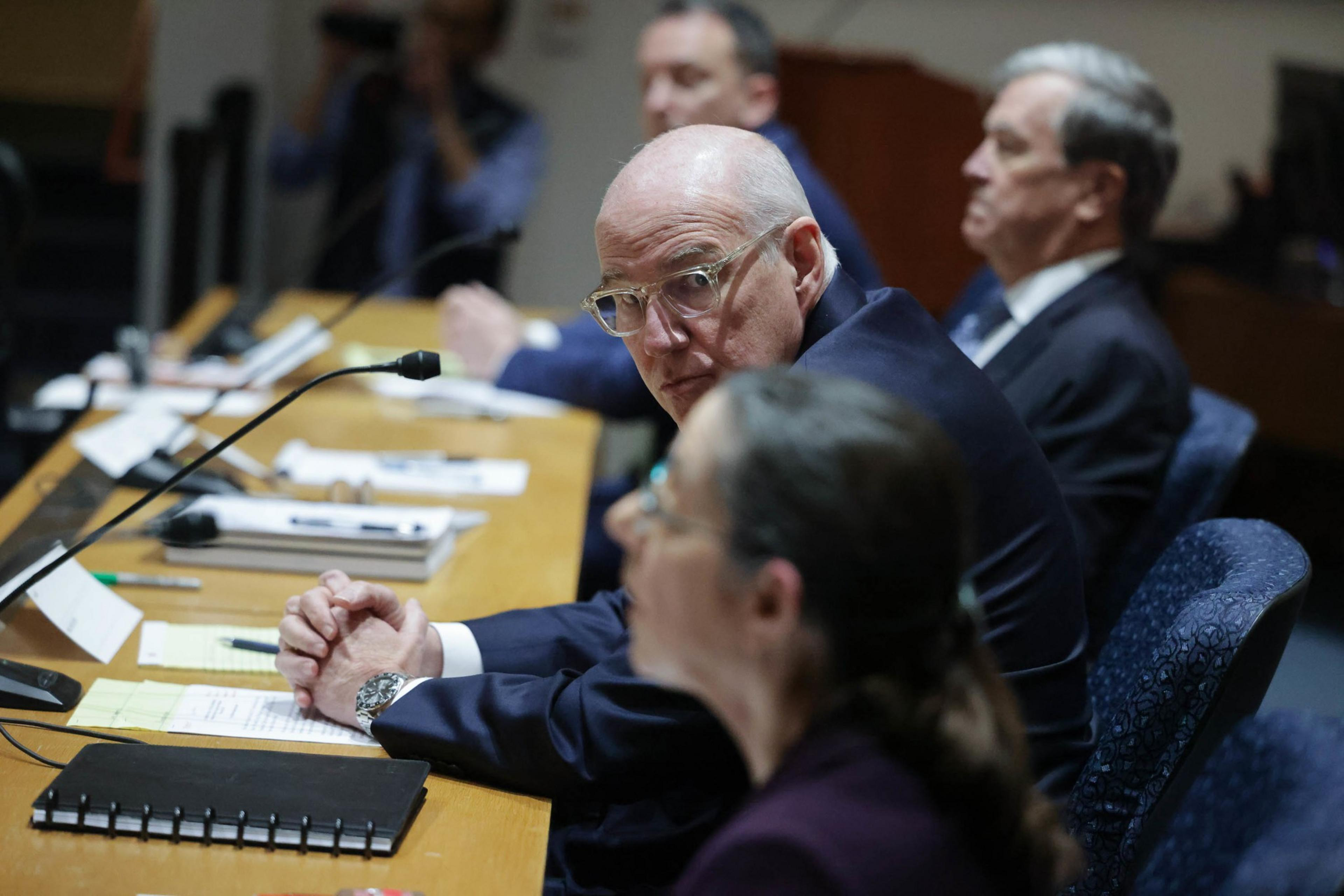 man in suit sitting at a table with other people