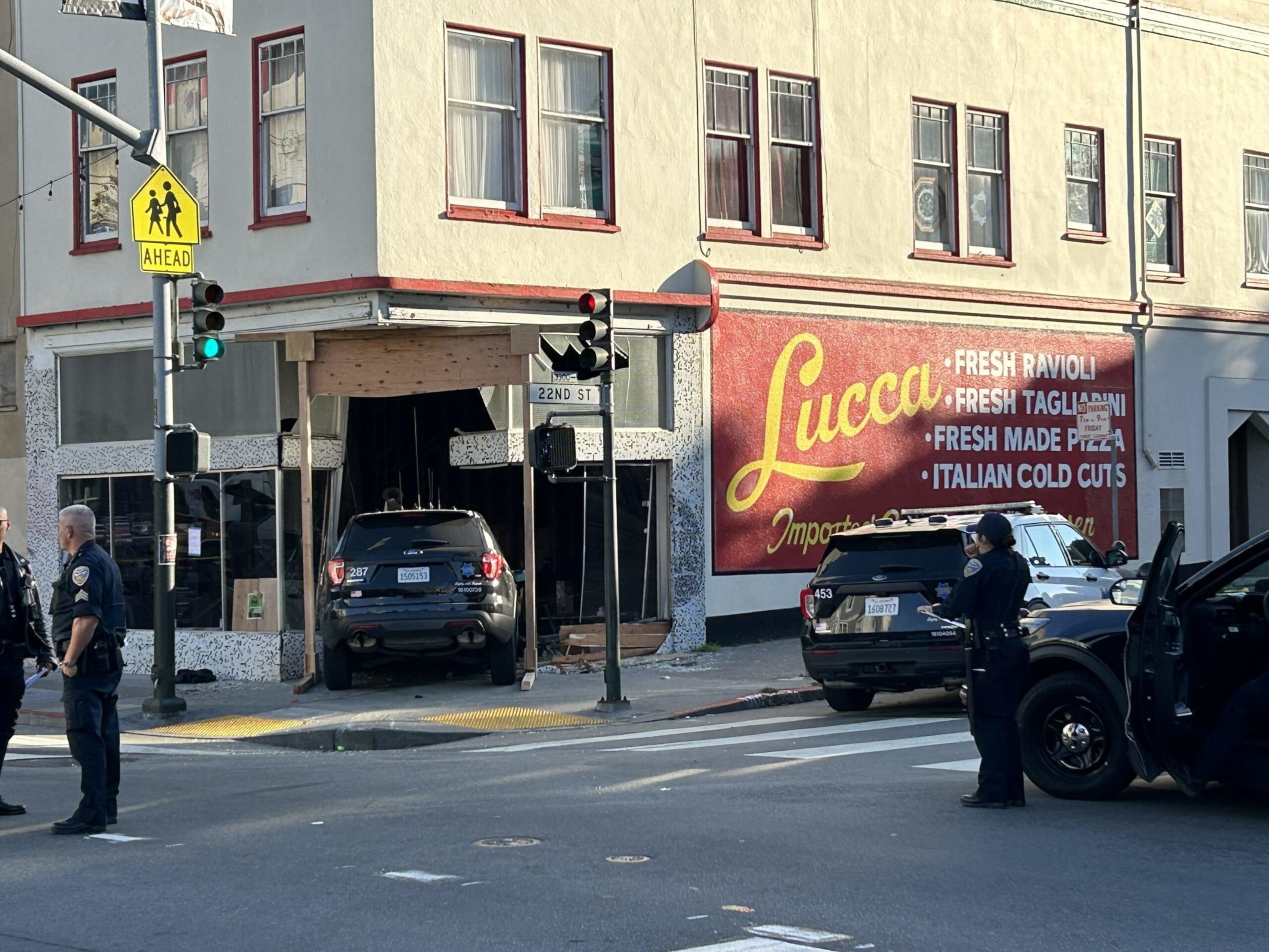A San Francisco police vehicle is wedged into the entrance of the former Lucca Ravioli at 22nd and Valencia streets in the Mission District on Wednesday. | Astrid Kane/The Standard