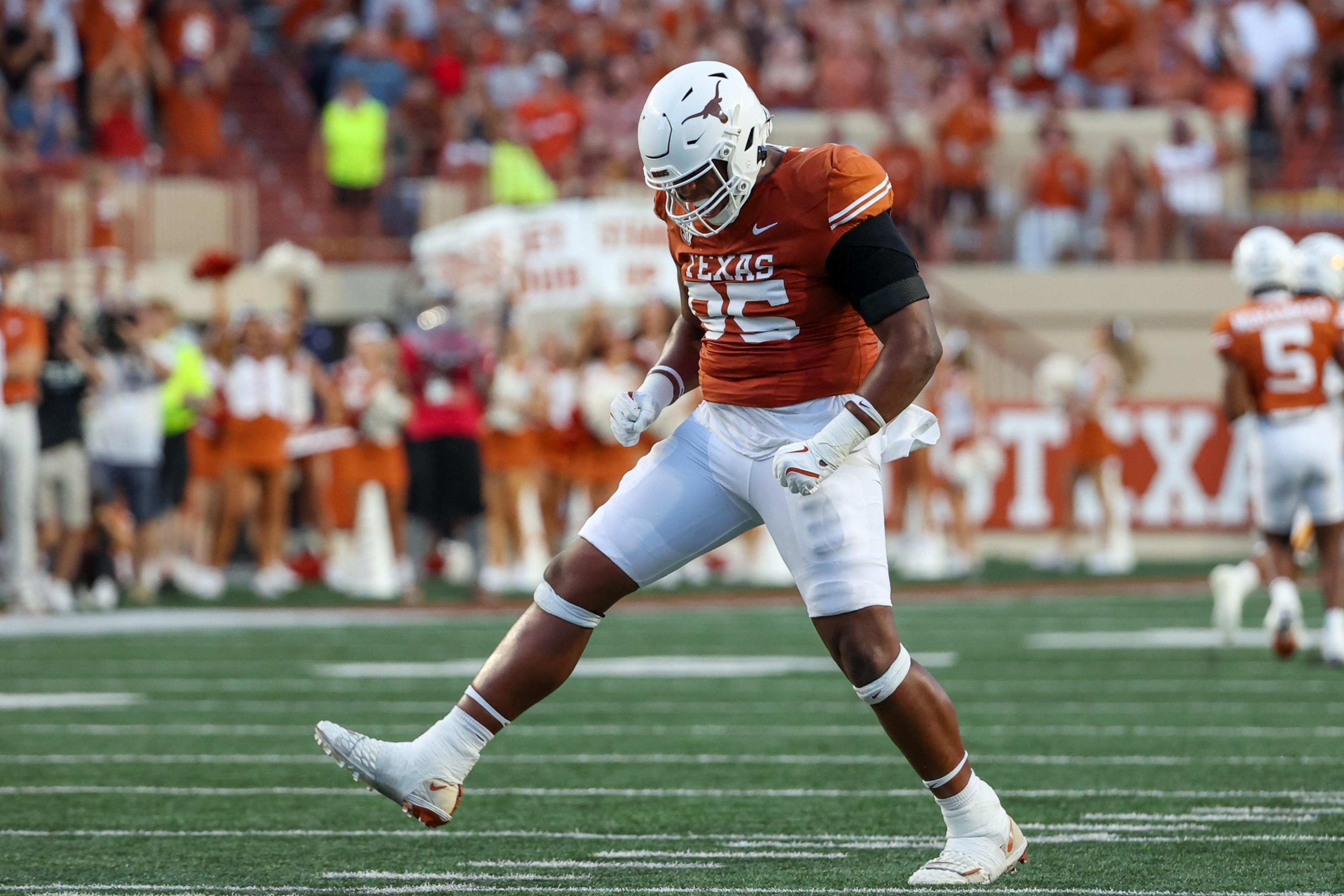 A football player in orange and white gear celebrates on the field. The background crowd and cheerleaders in similar colors add a lively atmosphere.