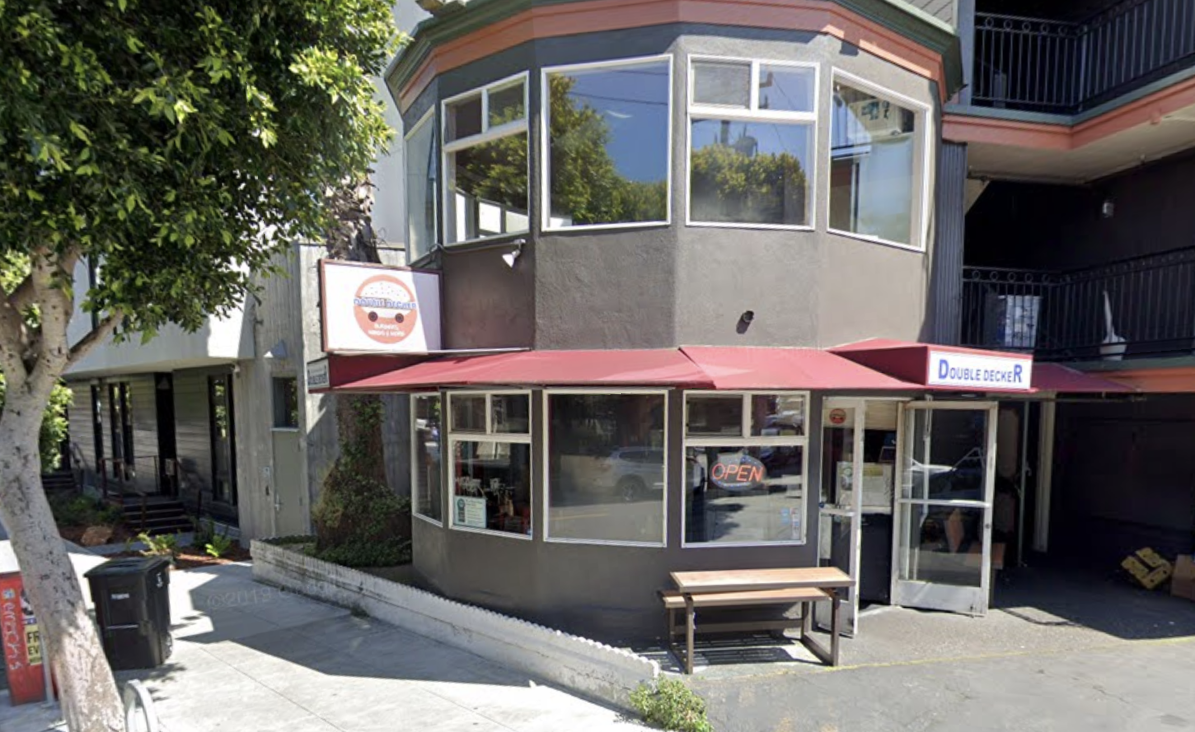 A round brown storefront with an open sign in the window