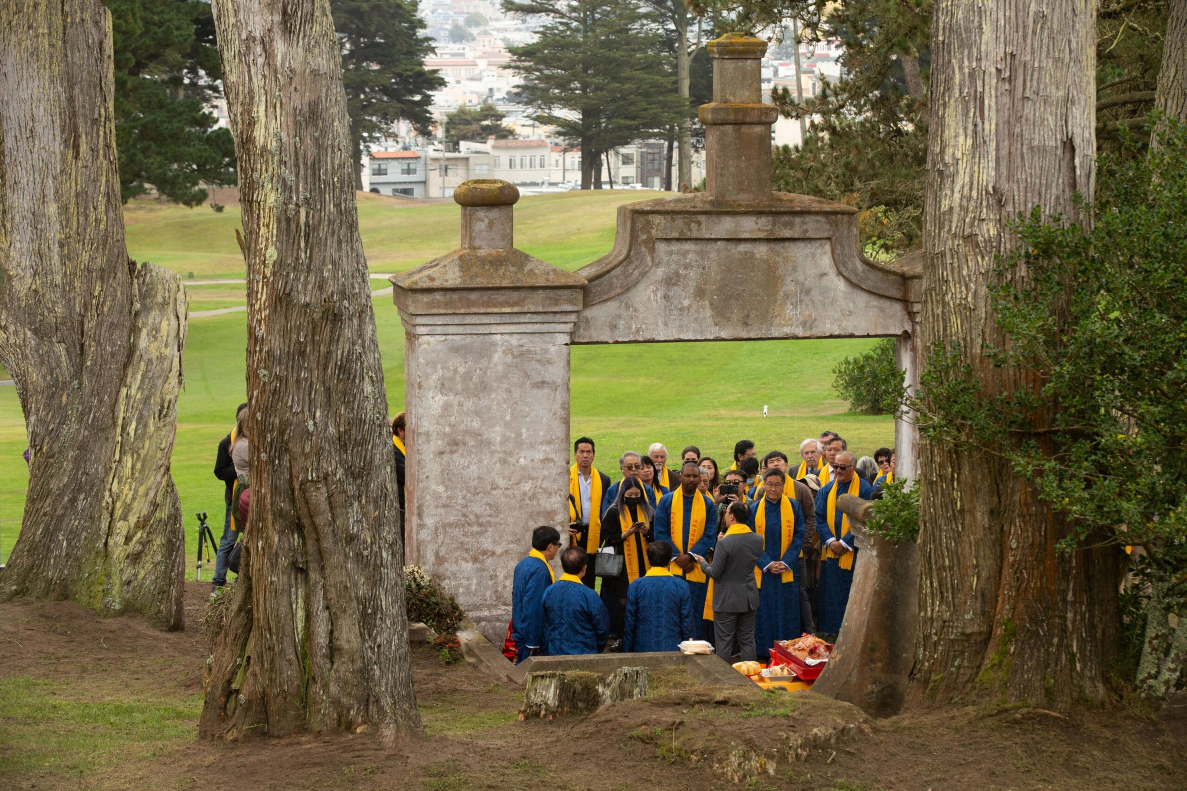 Dozens of people attend a ceremony outdoor.