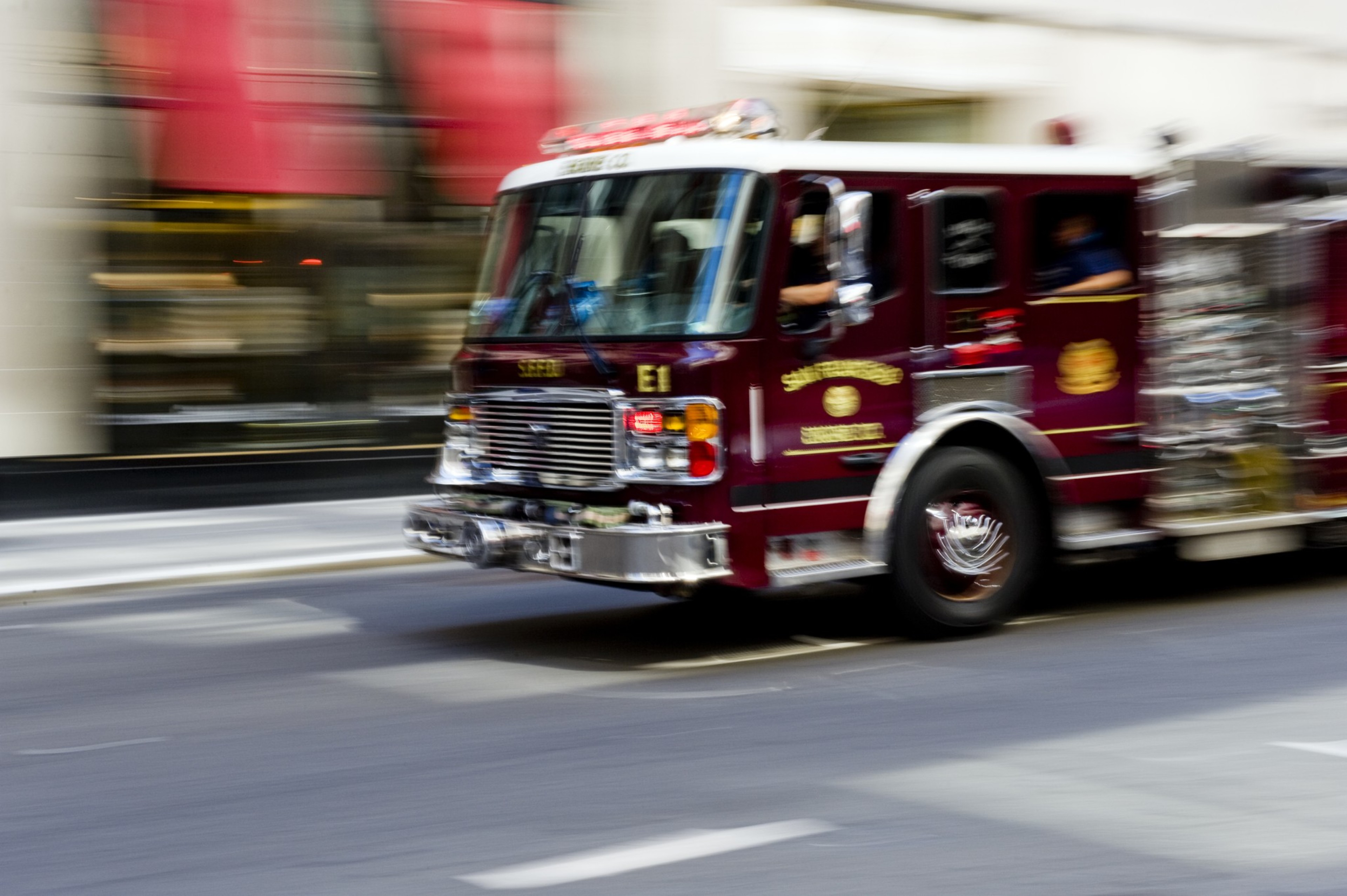 A fire truck races down a street.
