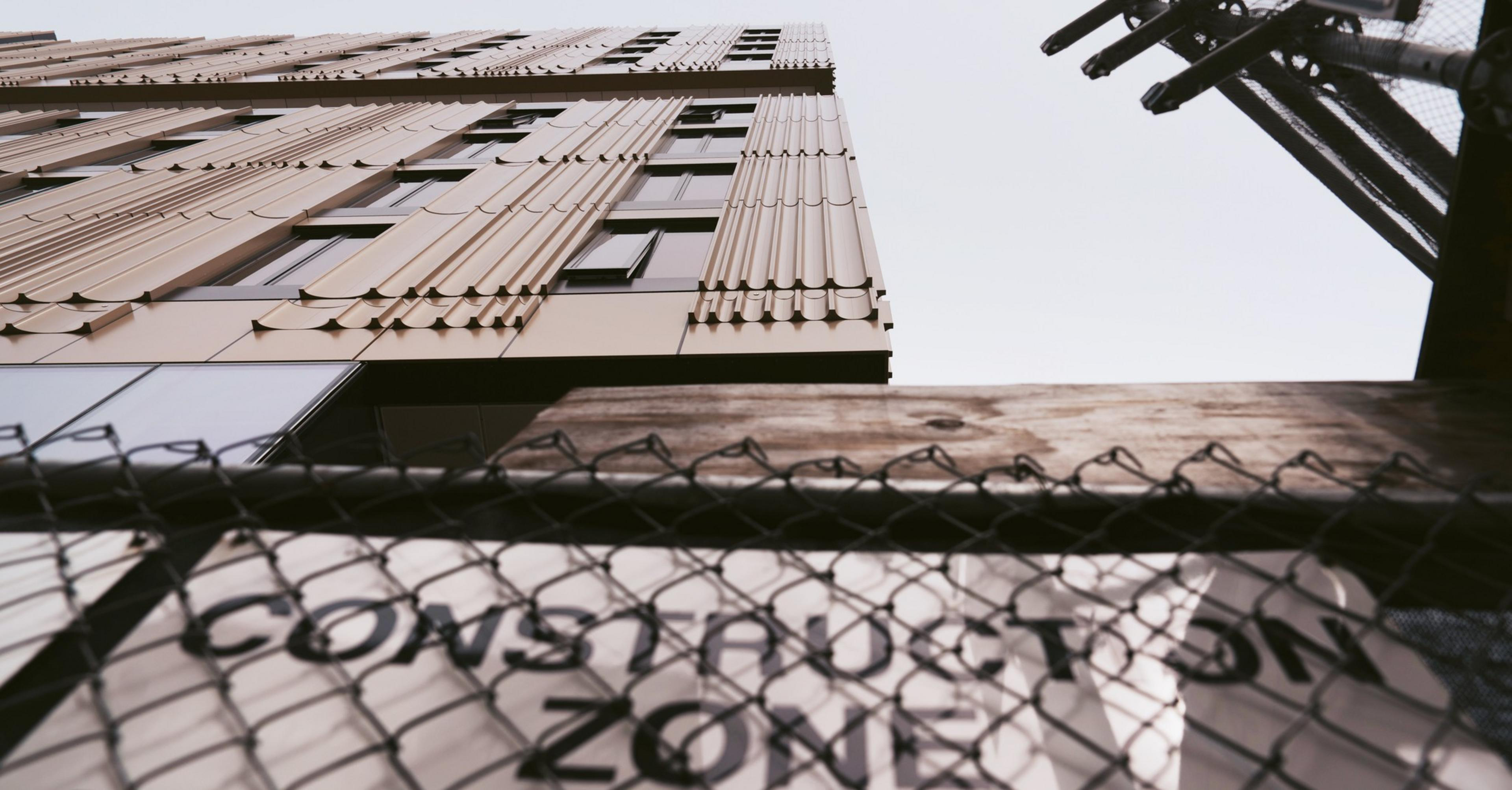 An housing development under construction with a sign that reads &quot;CONSTRUCTION ZONE&quot;