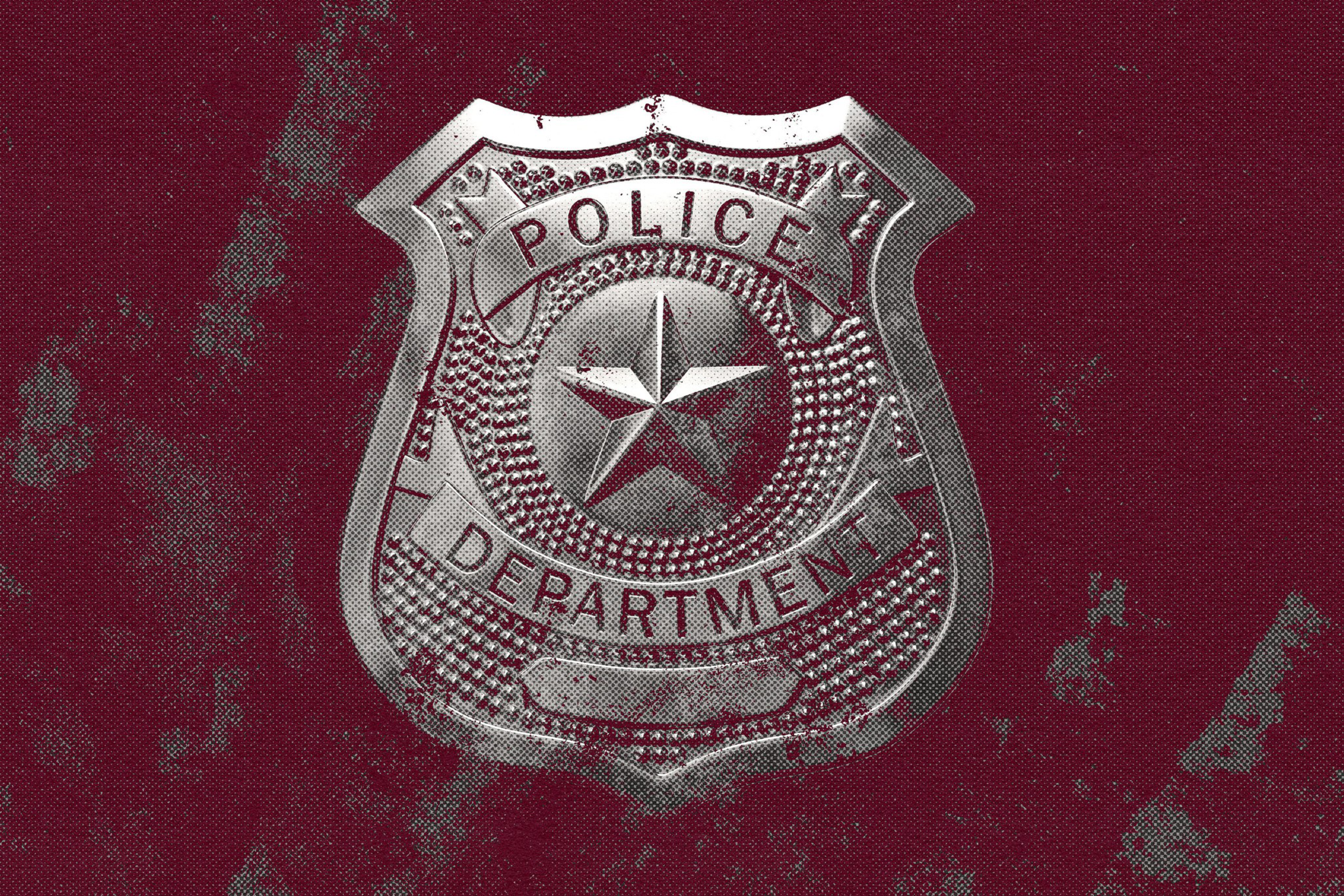A silver police badge with a star in the center and the words "Police Department" on a dark red textured background.